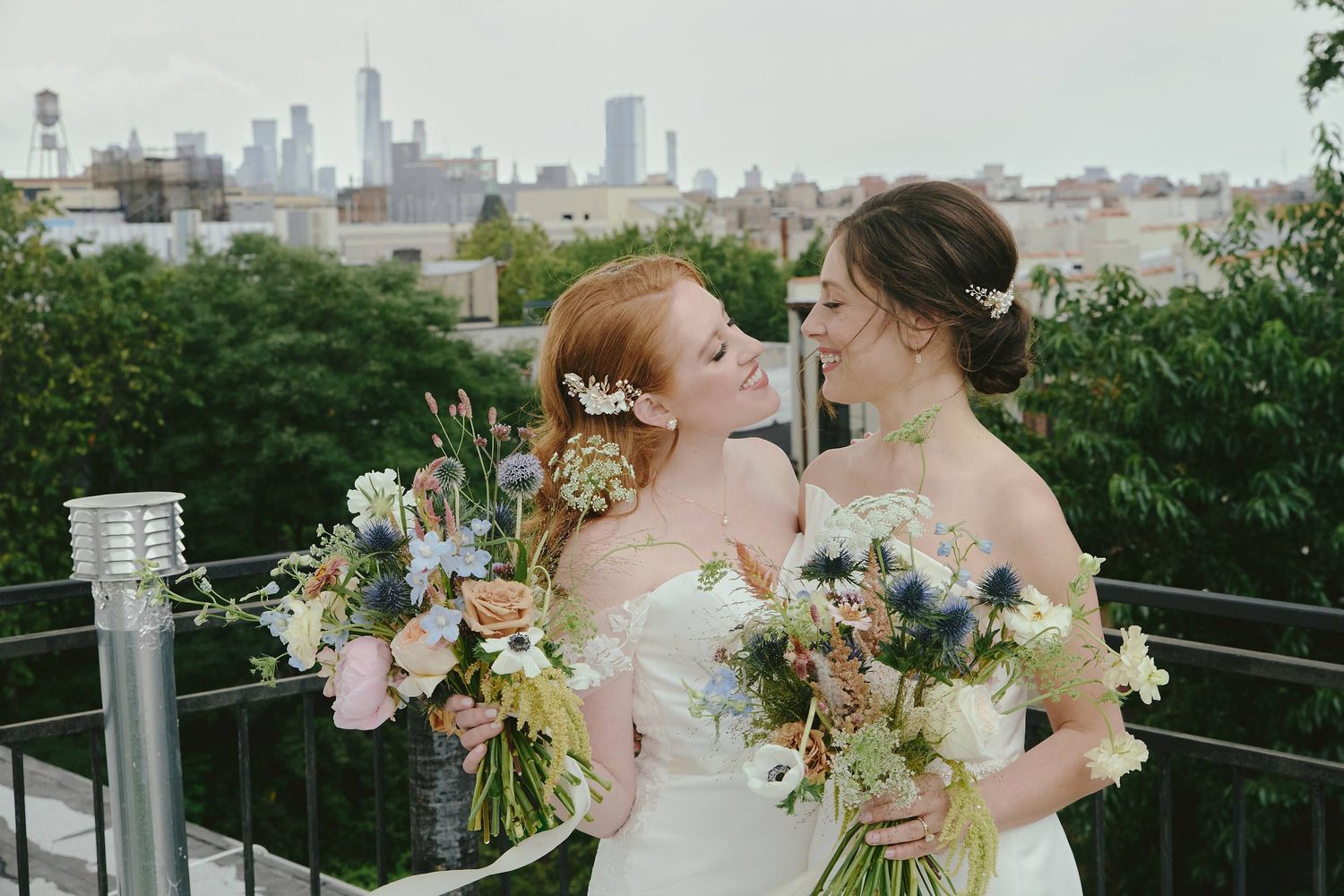 A beautiful wedding celebration on a rooftop garden with floral bouquets and the city skyline in the background.