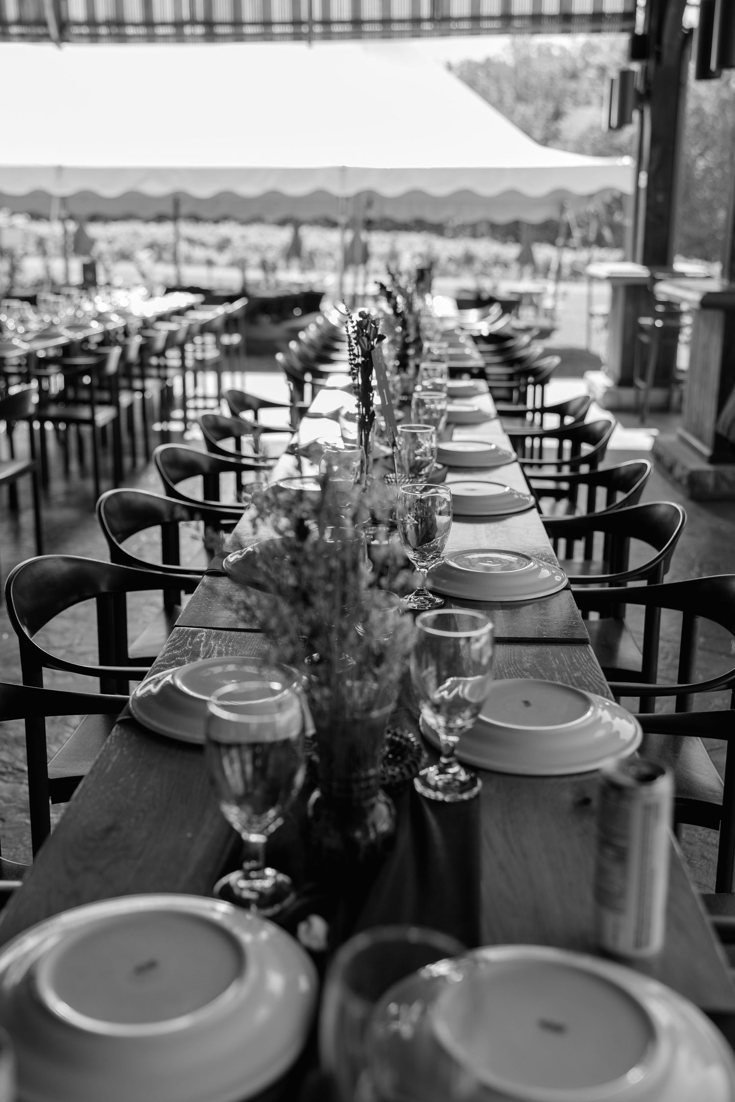 Elegant wedding reception tables set with white plates, wine glasses, and delicate floral centerpieces.