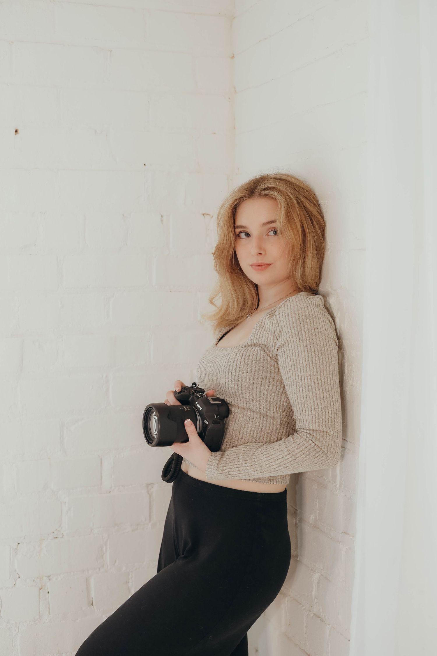 Studio photography demonstration featuring various camera holding techniques against white backdrop.