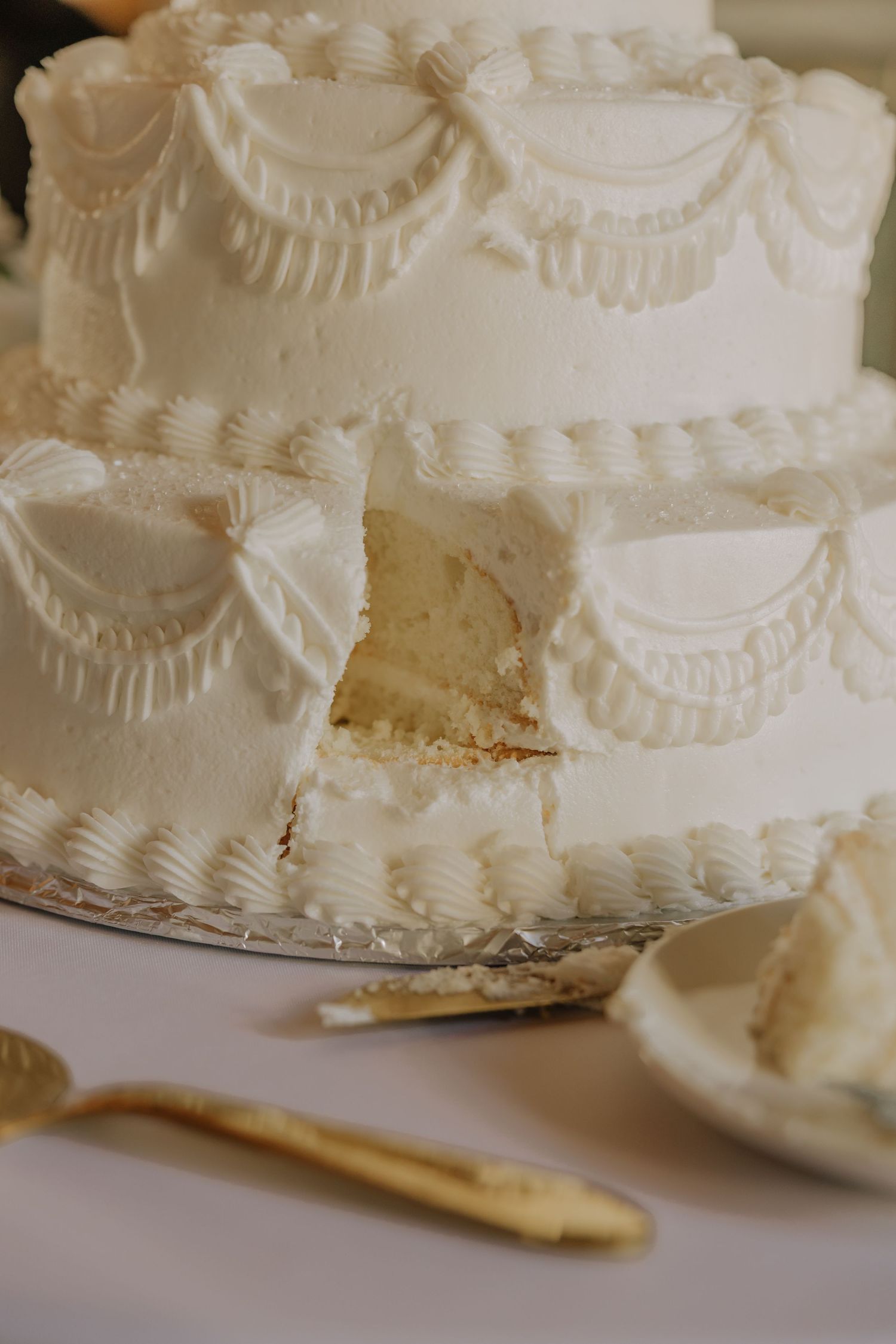 Close-up sequence showing slices being cut from a white frosted layer cake with decorative piped details.