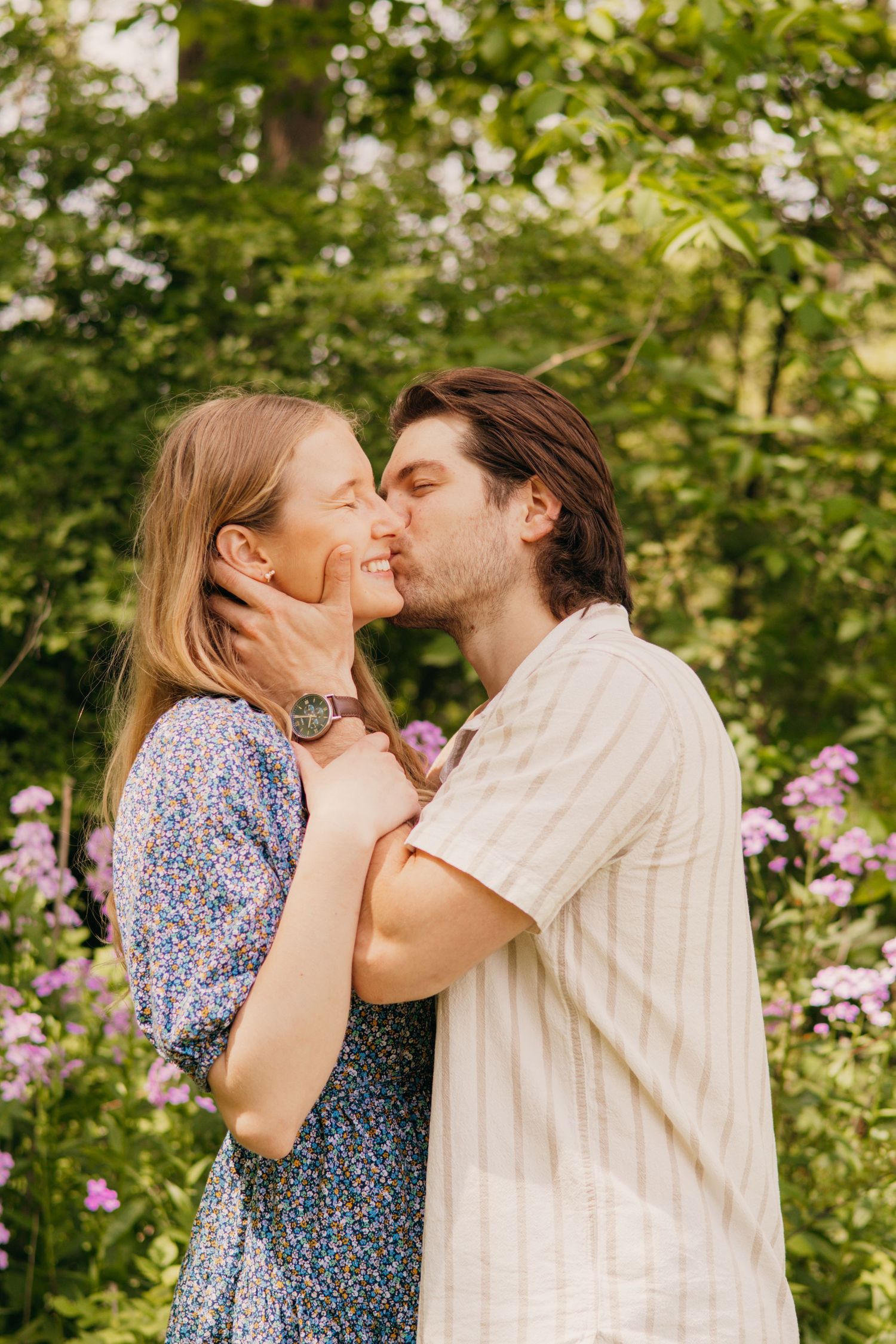 Romantic couple sharing intimate moment in blooming garden setting.