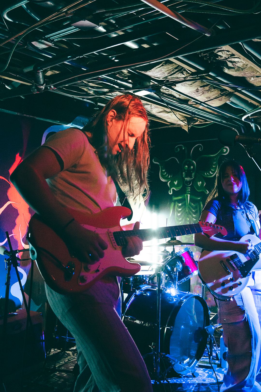 Band performing on stage with dramatic red and blue lighting effects.