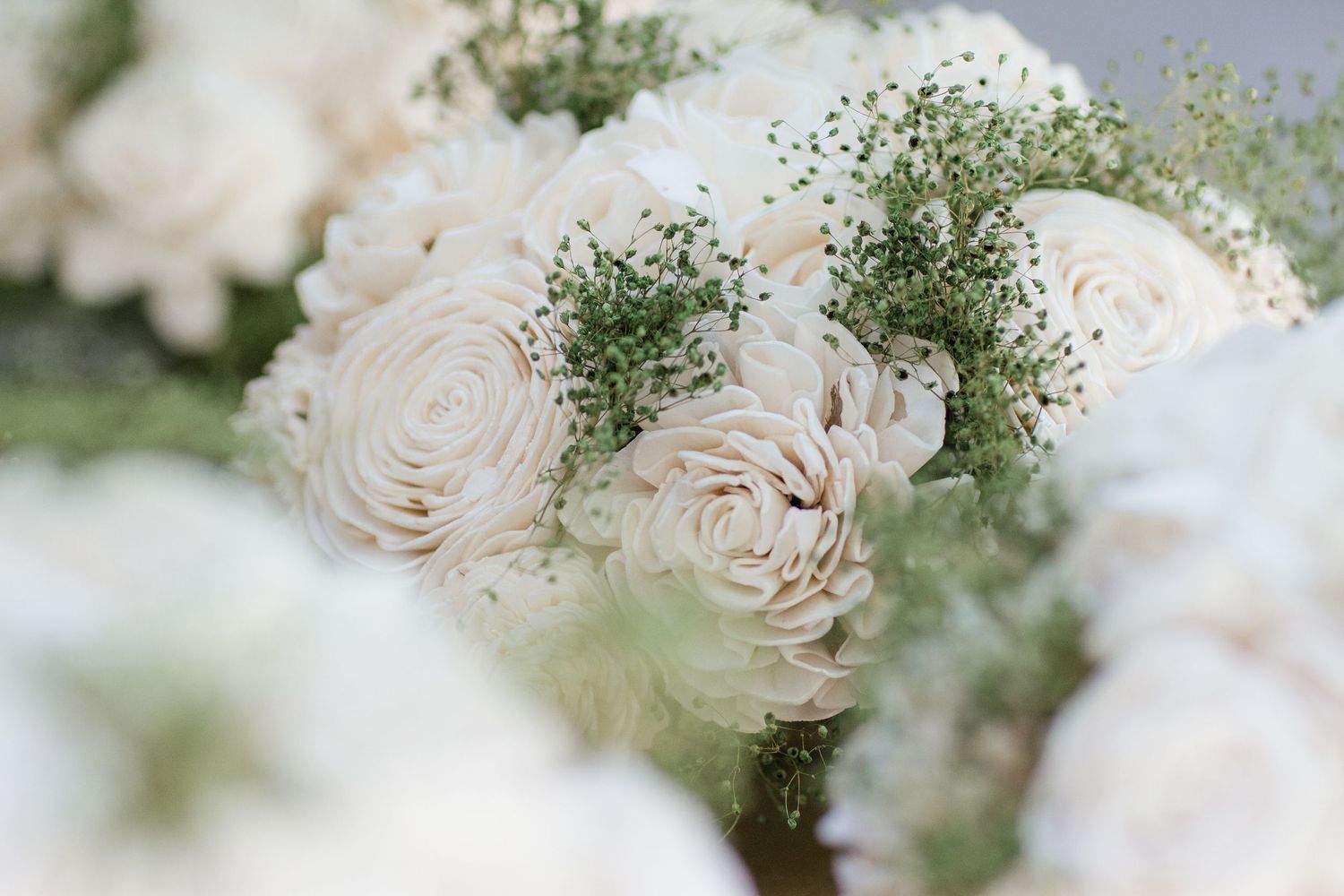 Elegant white roses and baby's breath flowers arranged in soft focus.