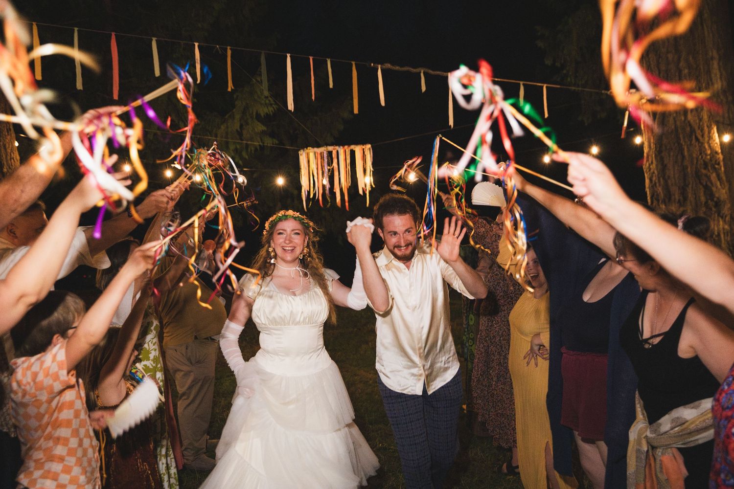 Wedding celebration with guests holding sparklers creating a magical nighttime atmosphere.