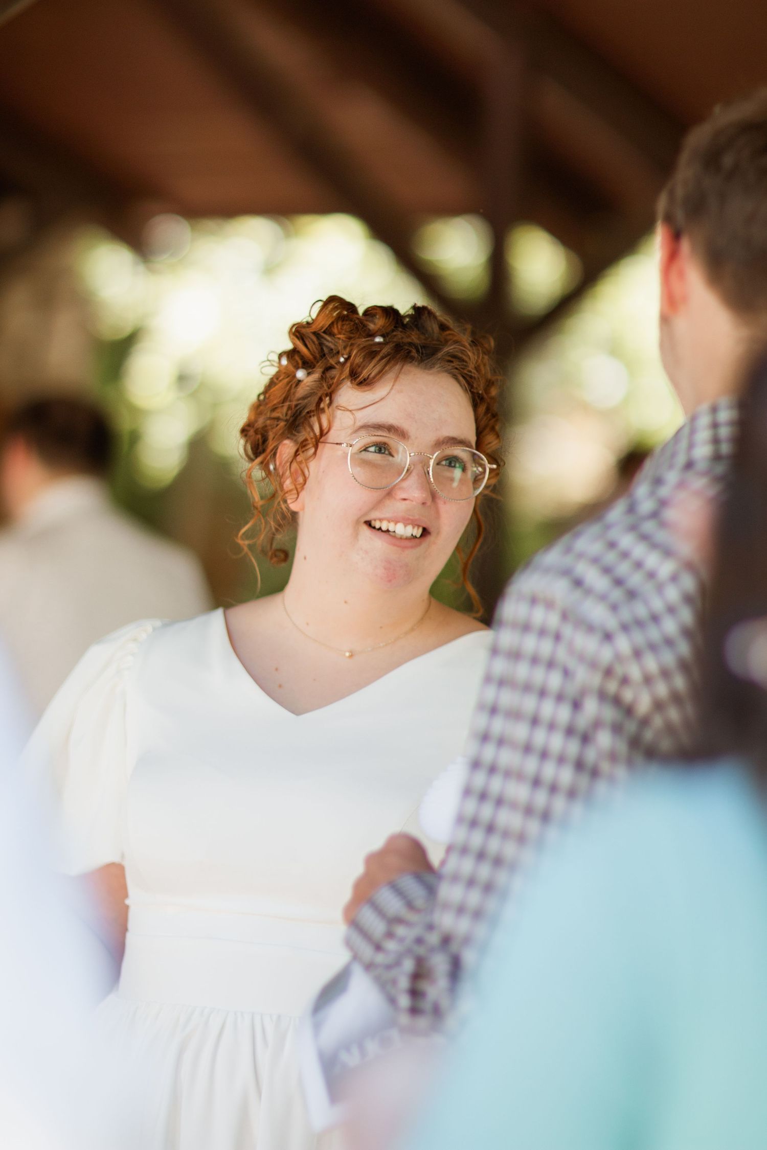 A candid moment during a wedding ceremony shows joyful expressions and a white dress.