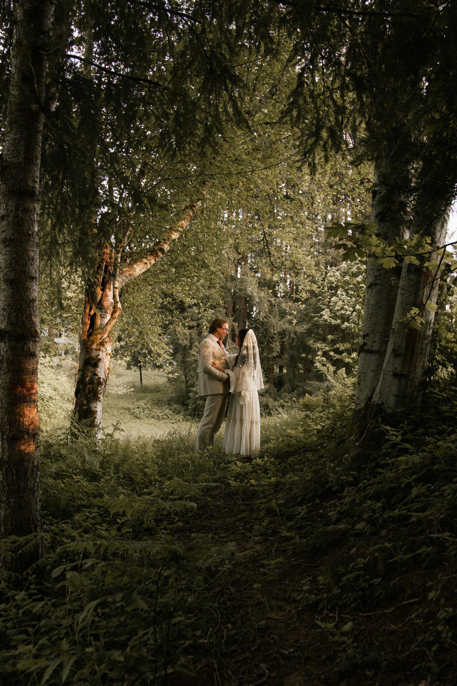 A dreamy forest scene with sunlight filtering through trees and ethereal white clothing.