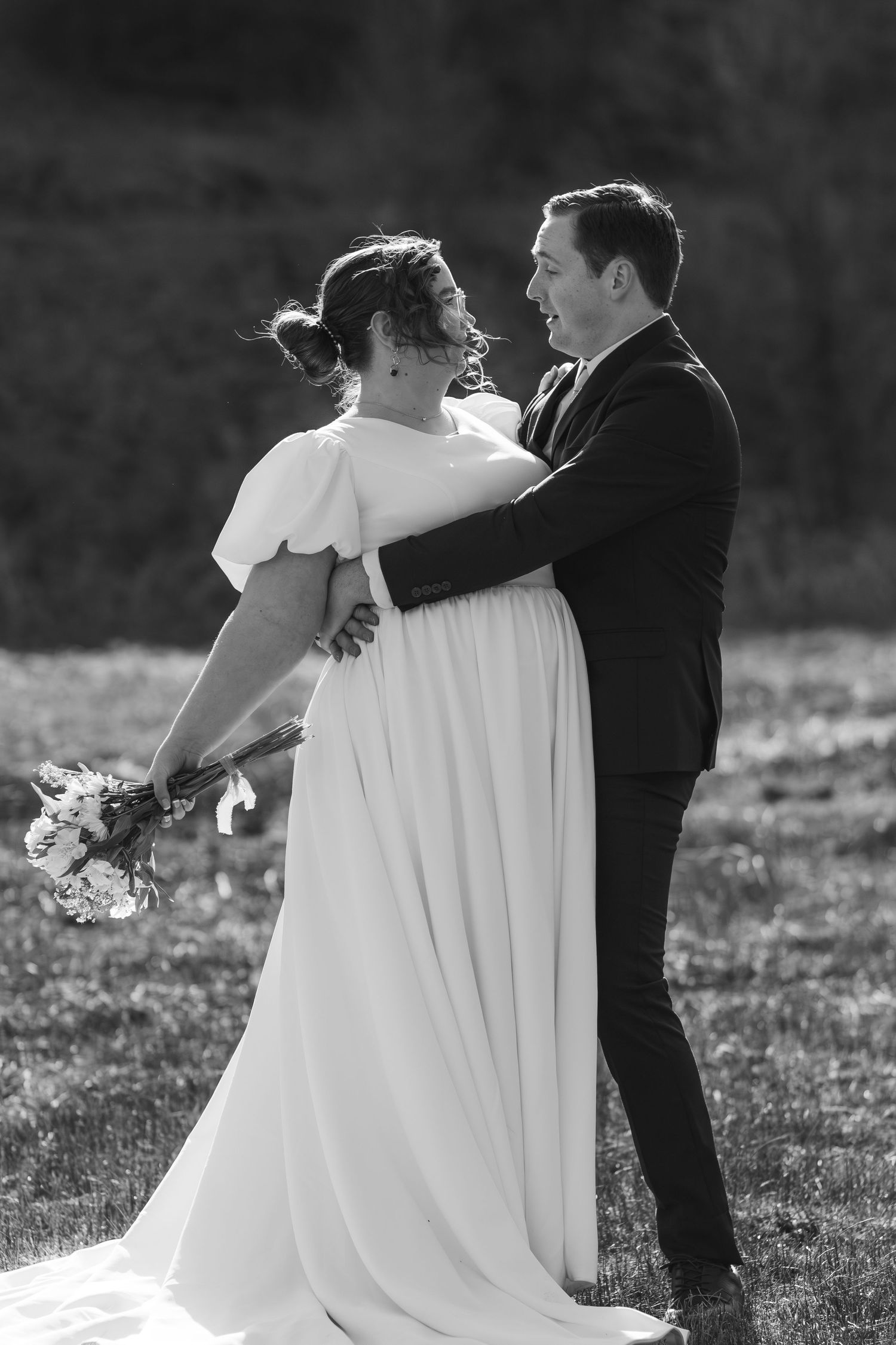 Black and white wedding photo of a couple in an intimate embrace on their special day.