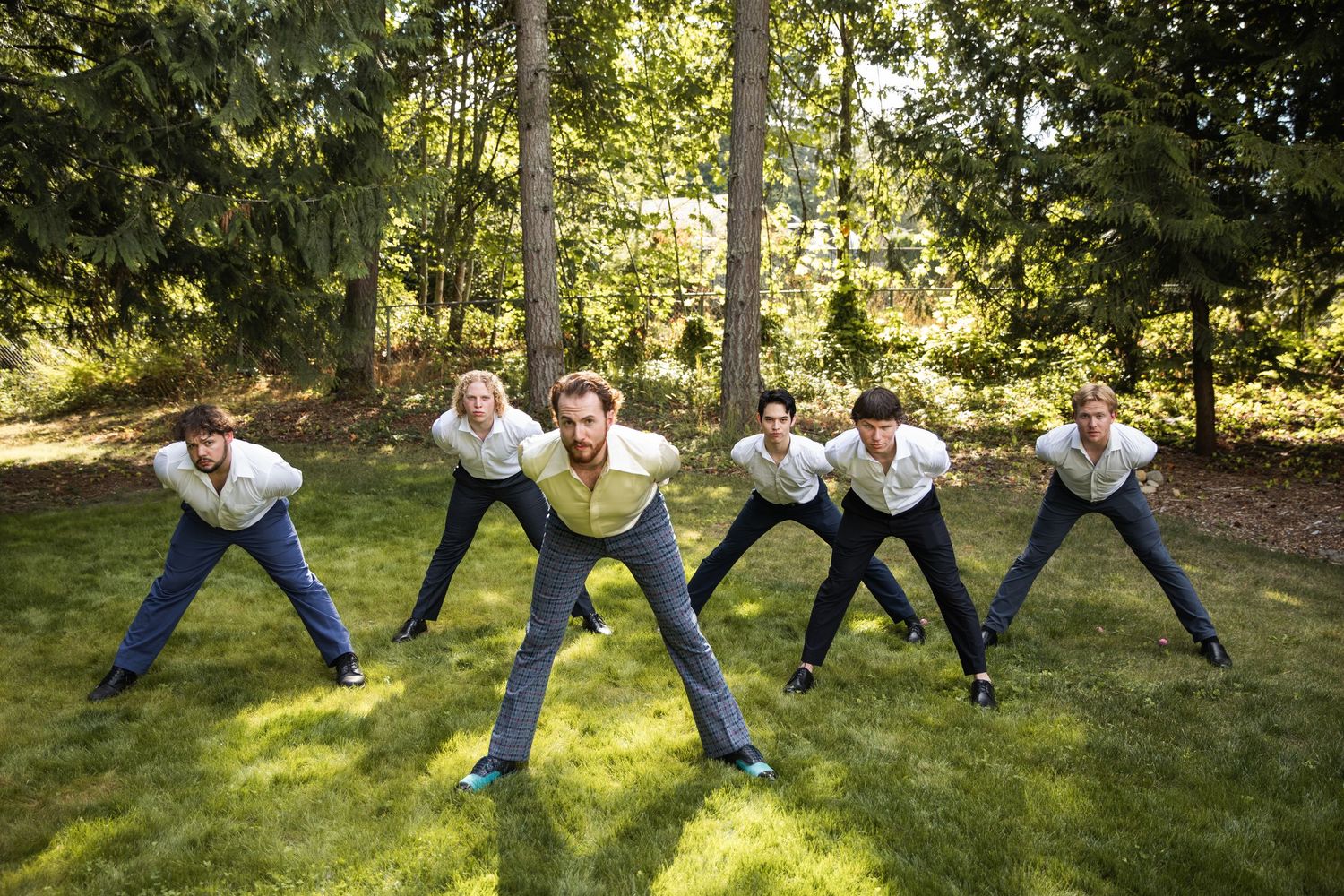 Groomsmen perform synchronized jumping poses on grass in a playful wedding photo sequence.