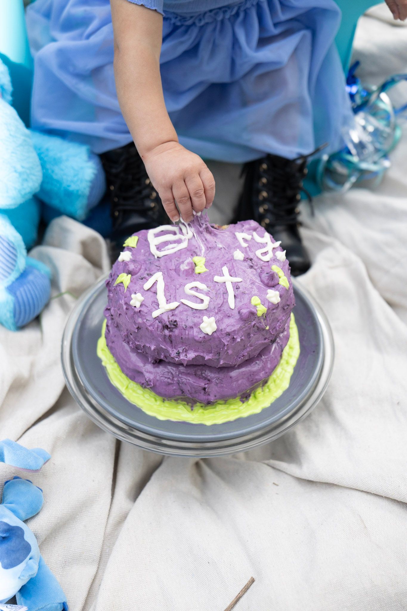 Baby's hand grabbing for a cake that say's 
