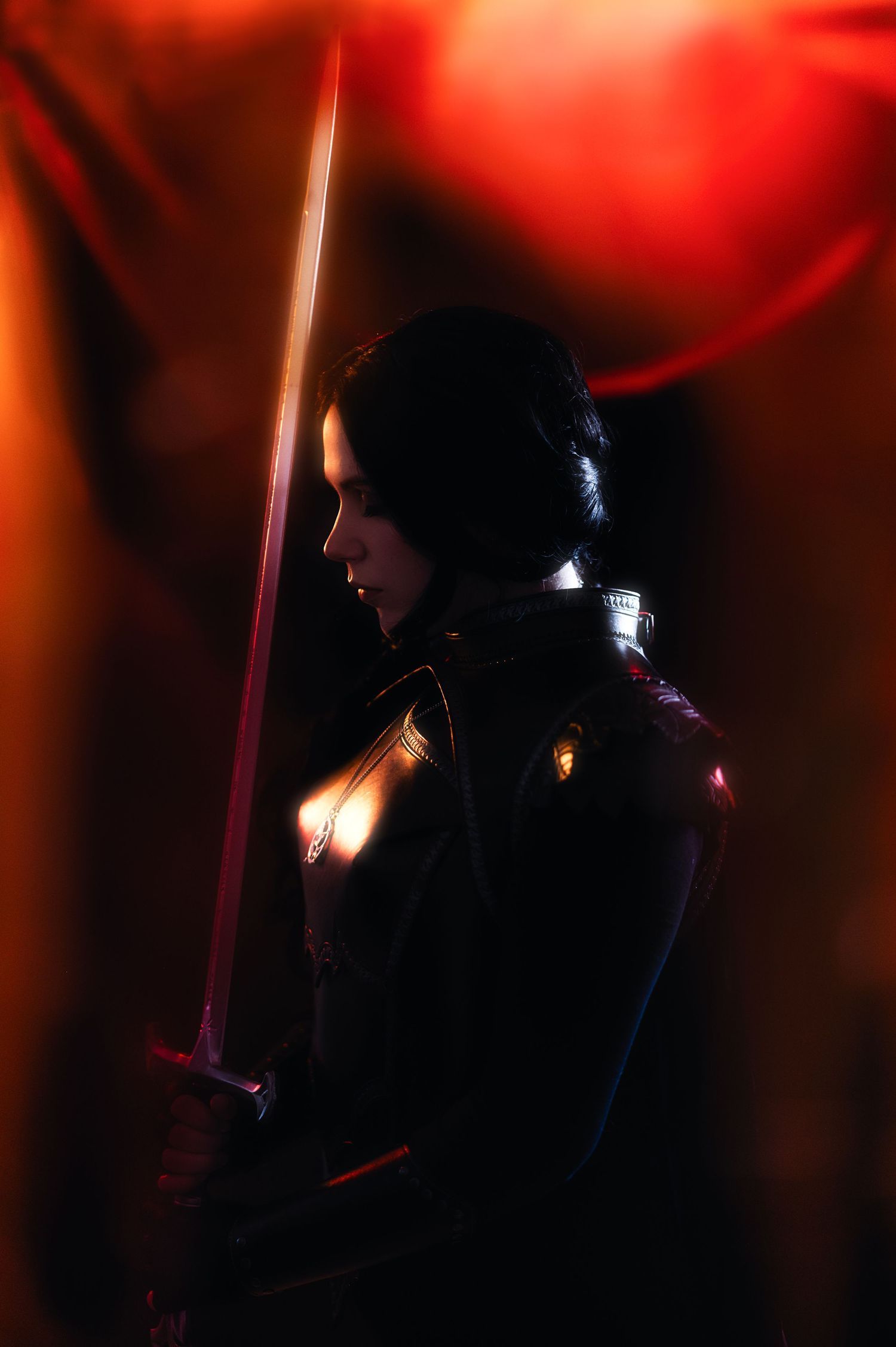 Silhouetted figures in a dark setting illuminated by dramatic red lighting effects create a moody atmospheric scene.