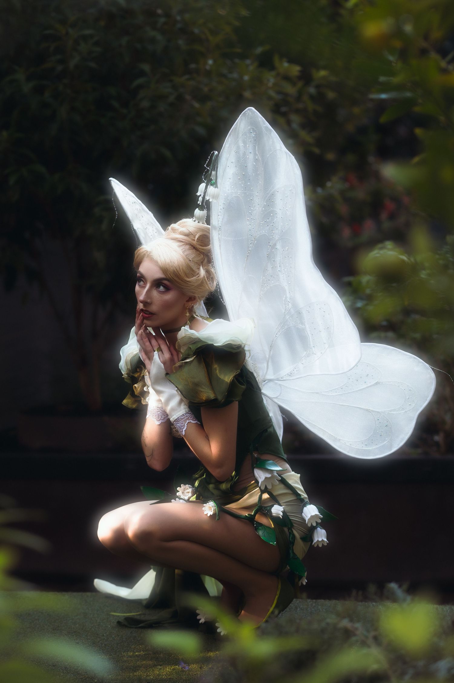 Fairy costume photography featuring illuminated wings and dynamic poses in garden setting.