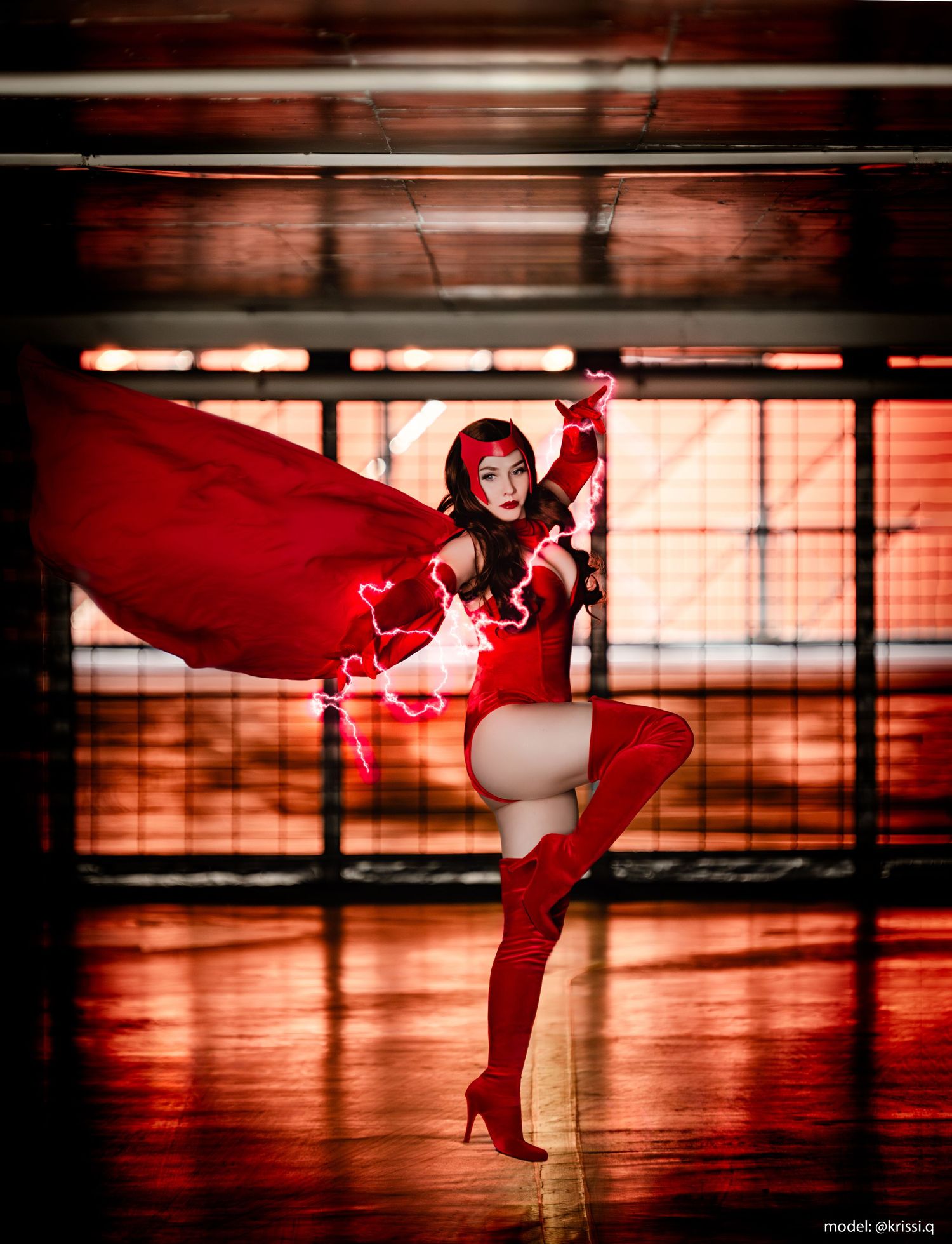 Dynamic cosplay photo featuring red costume and cape with electrical effects in an industrial space.