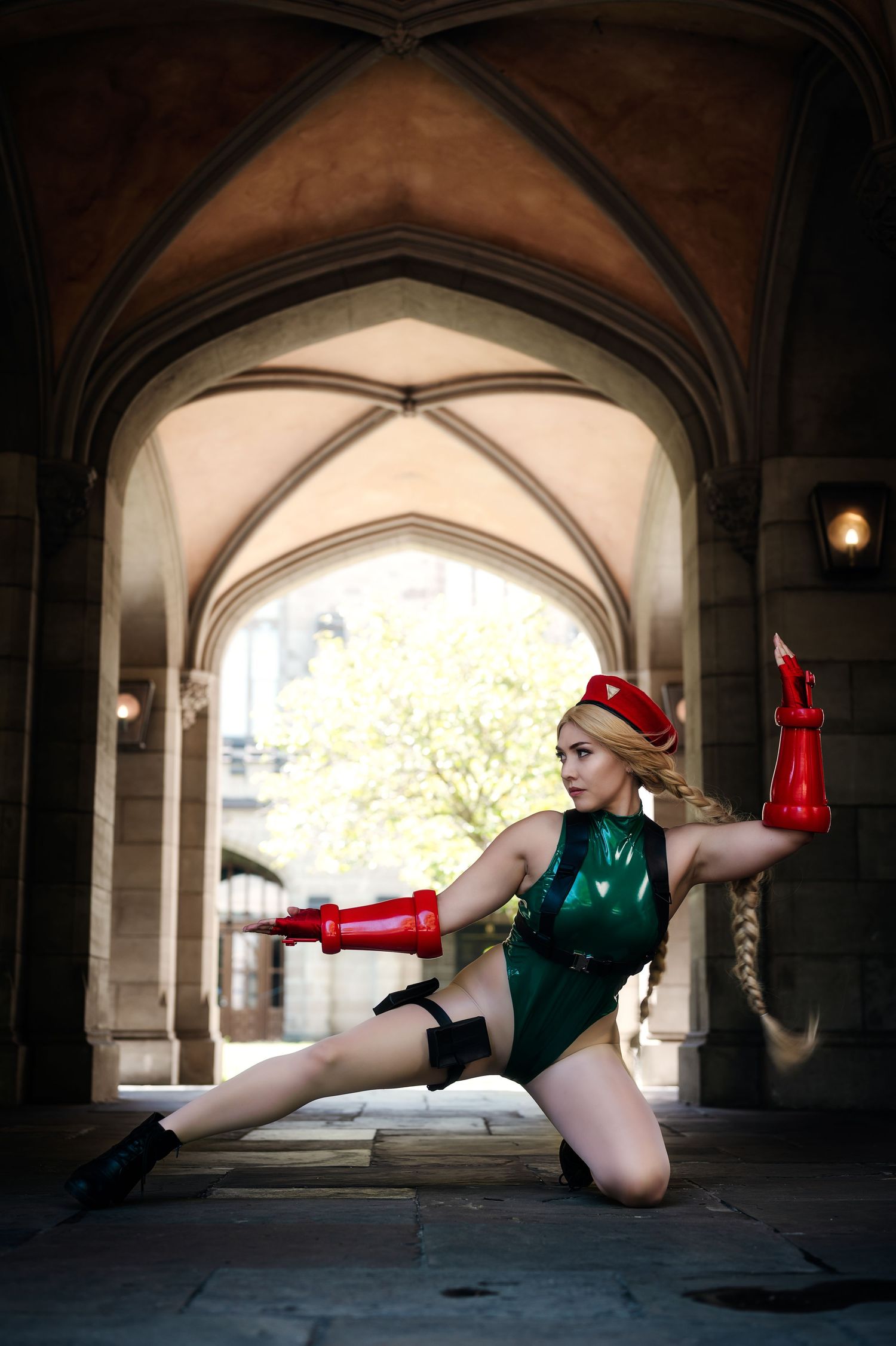 Dynamic cosplay pose under gothic architecture with dramatic lighting and arched ceiling.