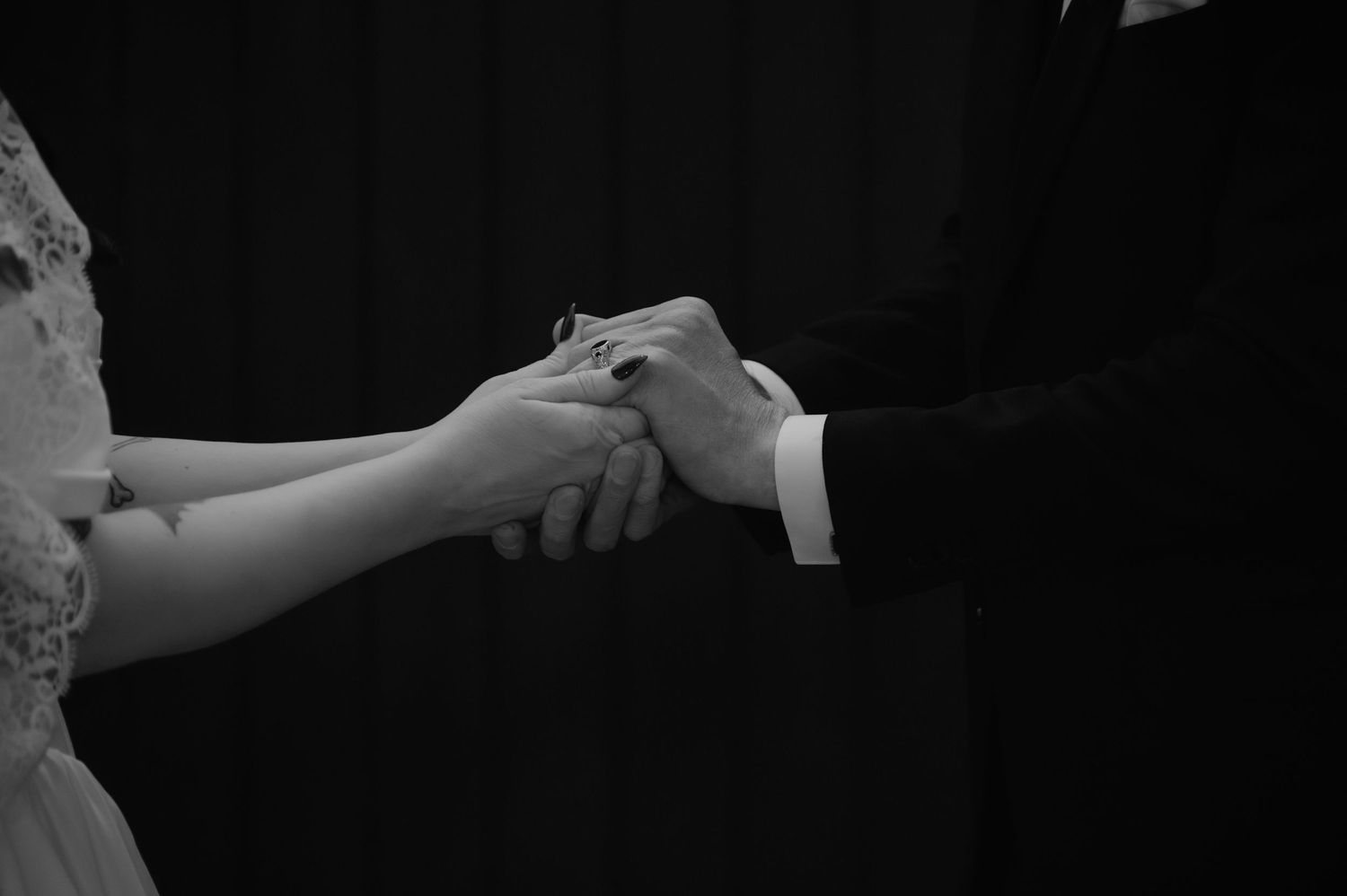 Close-up of hands exchanging rings during a wedding ceremony.