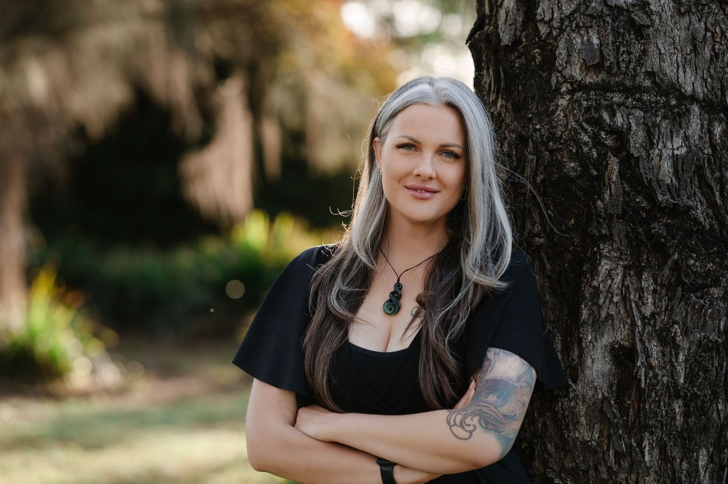 Portrait session outdoors with natural lighting against tree backdrop.