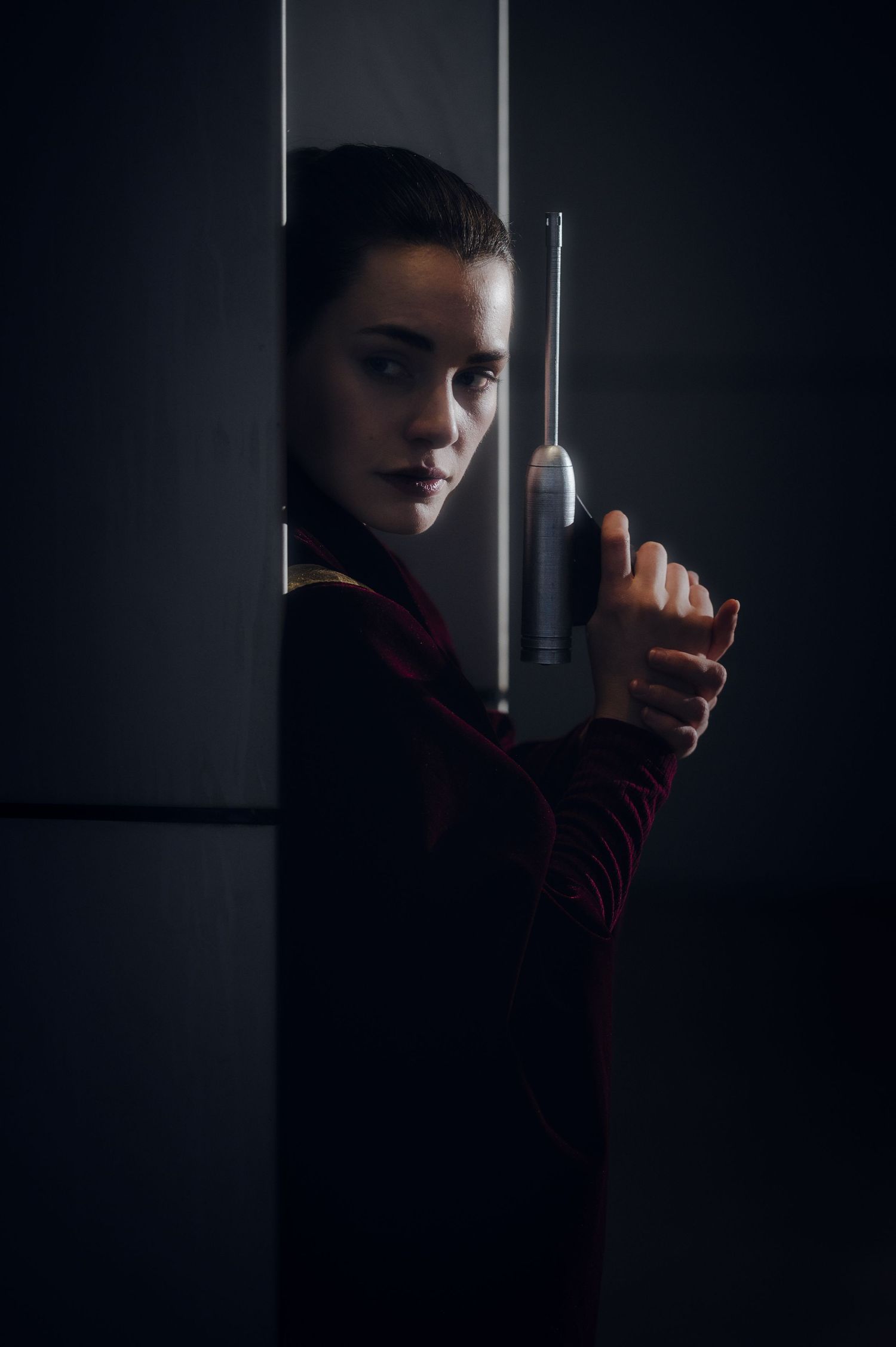 Dark and moody portrait with dramatic side lighting and deep shadows.