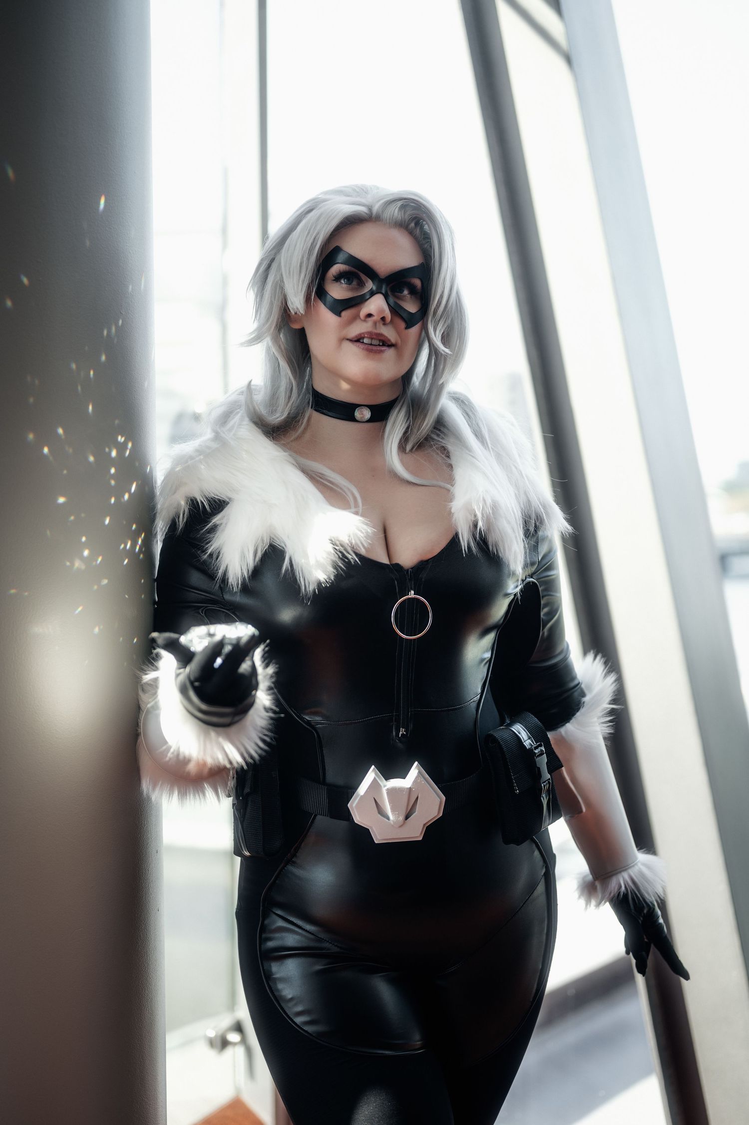 Modern cosplay portrait with black leather and white fur against bright windows.