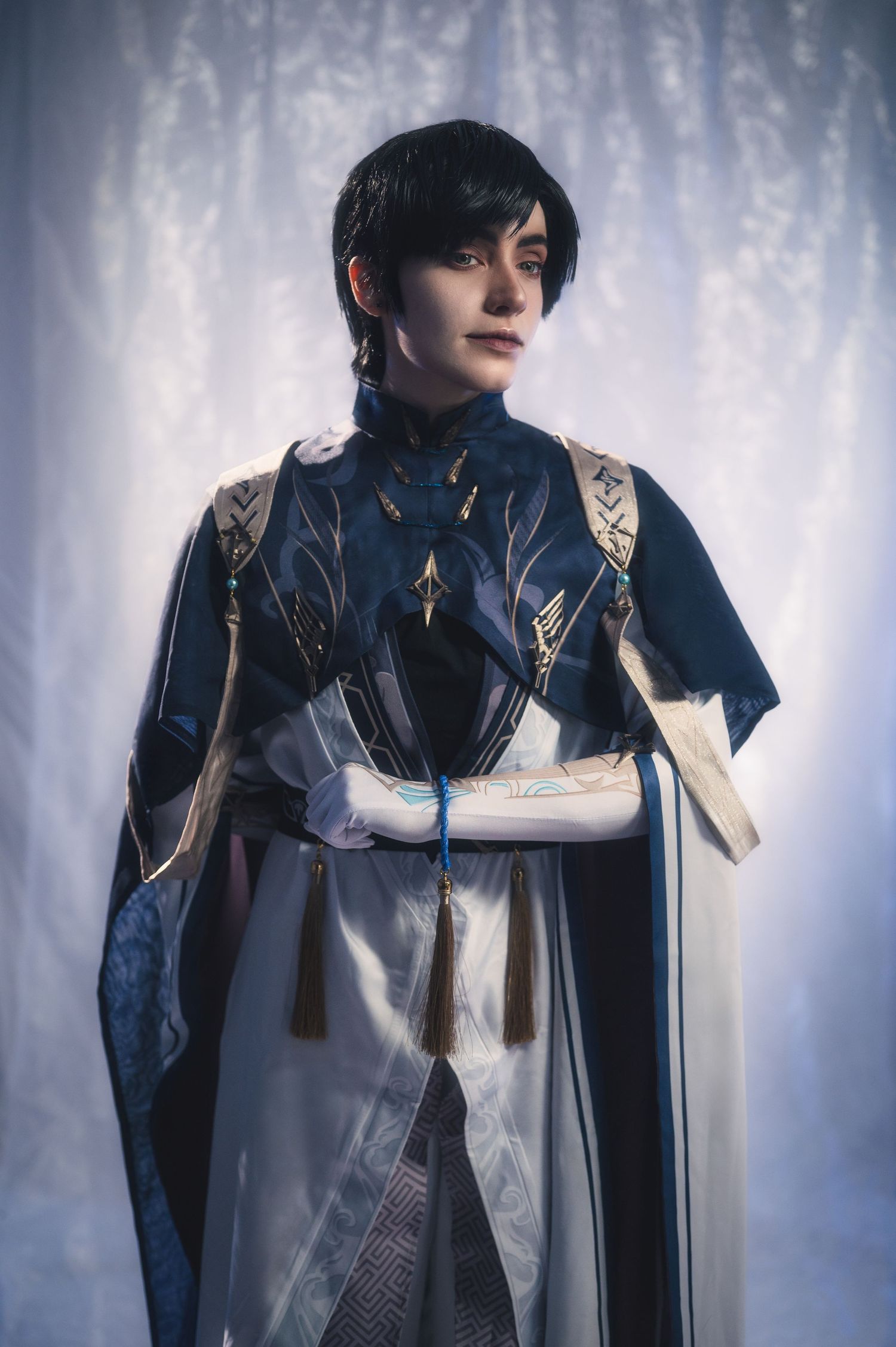 Elegant costume photography with intricate white and navy design elements.