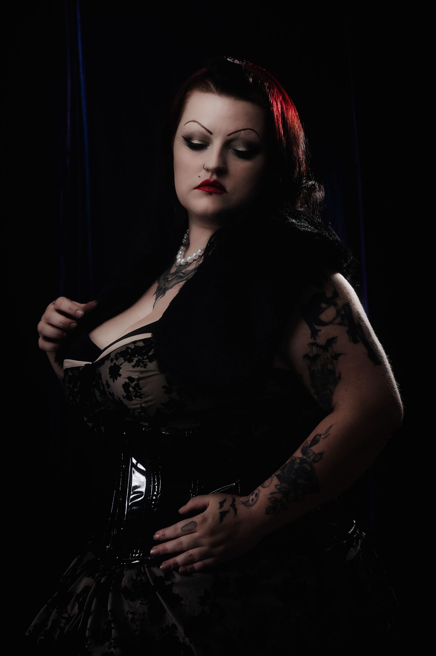 Dramatic low-key portraits with red accent lighting showcase gothic fashion styling.