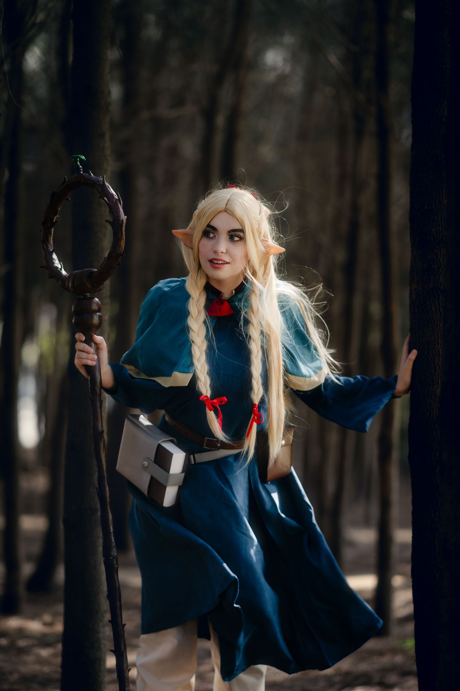 Fantasy character with blonde braids and blue dress moves dynamically through dark woods.