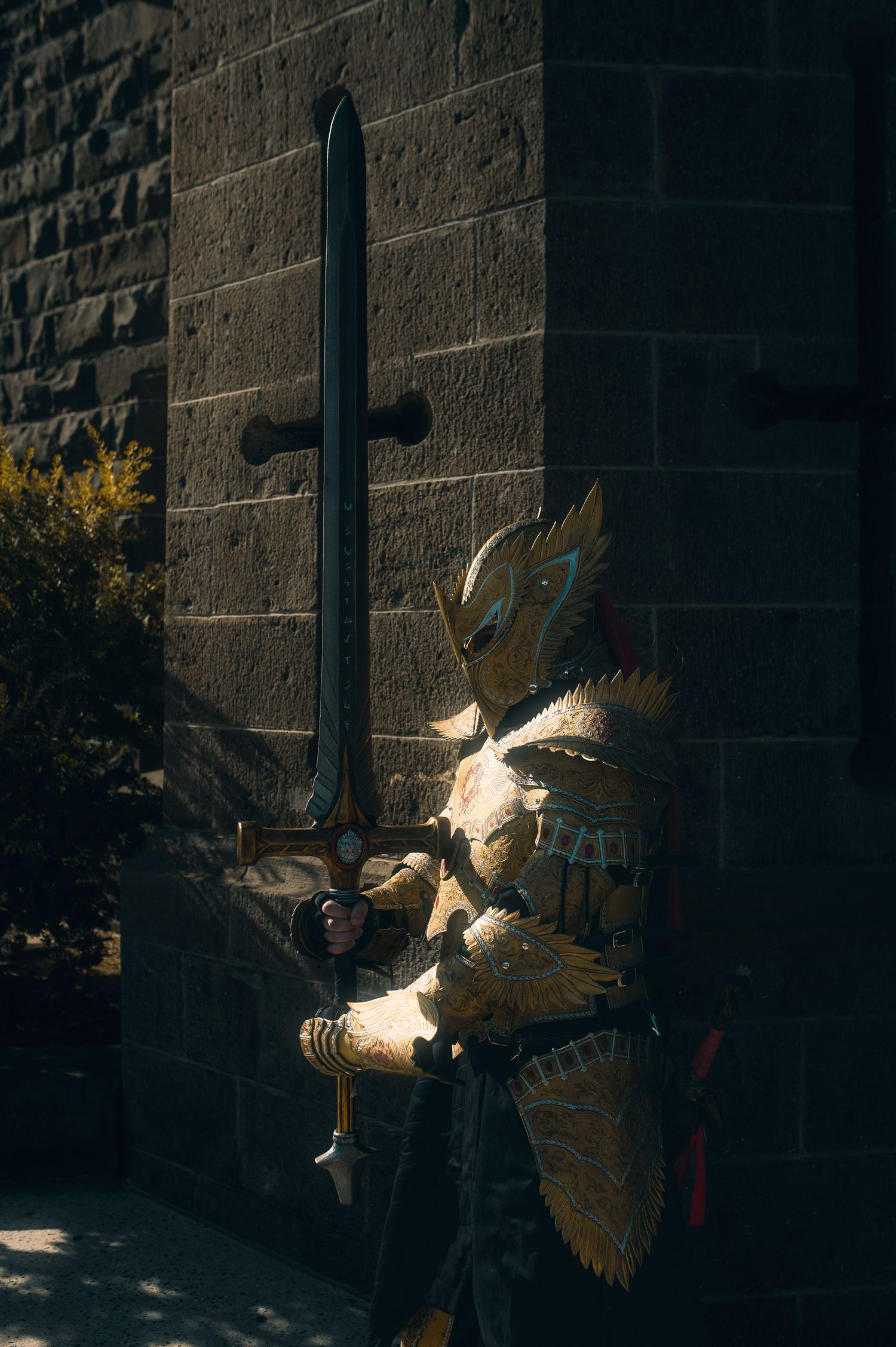 Golden-armored warrior battles in dramatic lighting against castle stone walls.