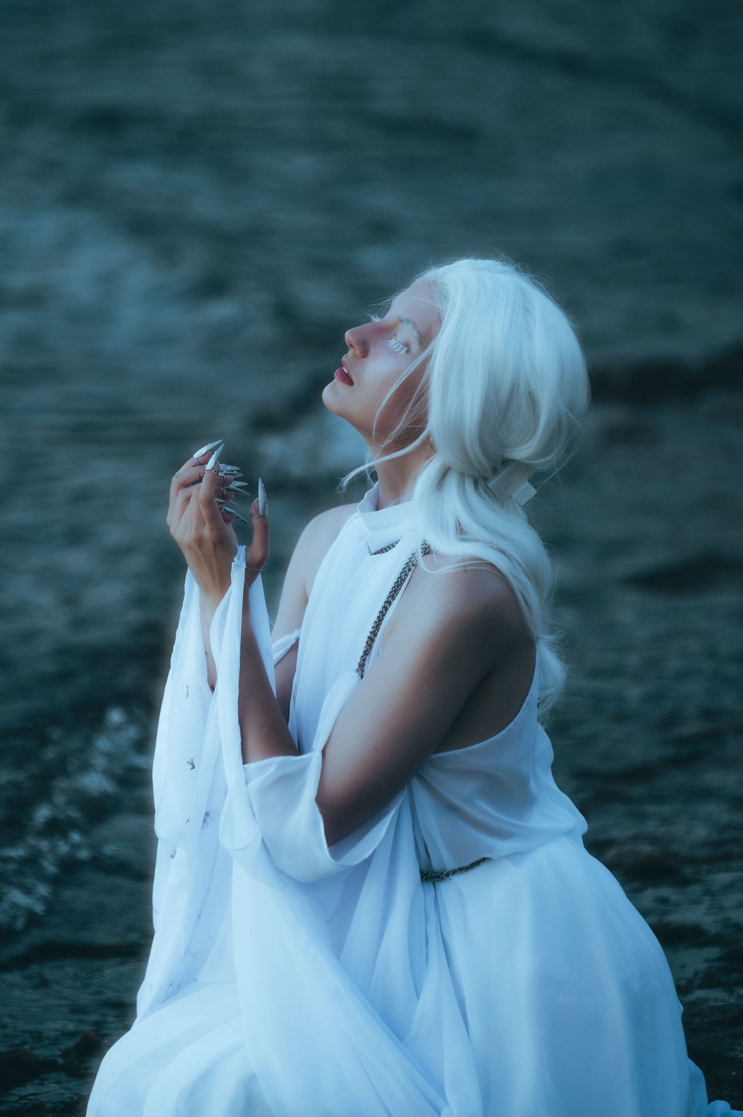 Figure in flowing white dress poses dramatically against dark background in artistic triptych composition.