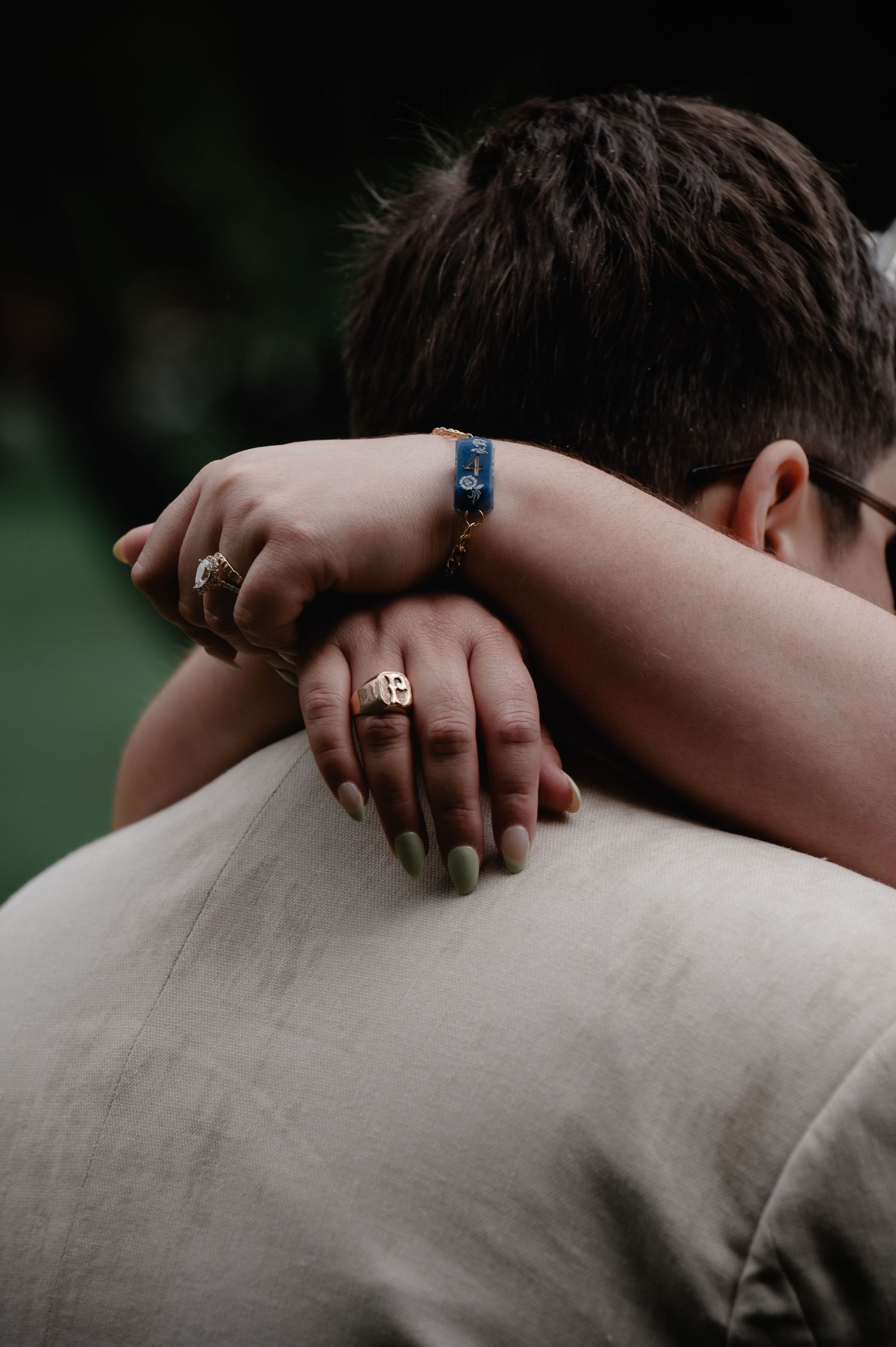 Close-up of wedding rings and embracing hands during an intimate moment.