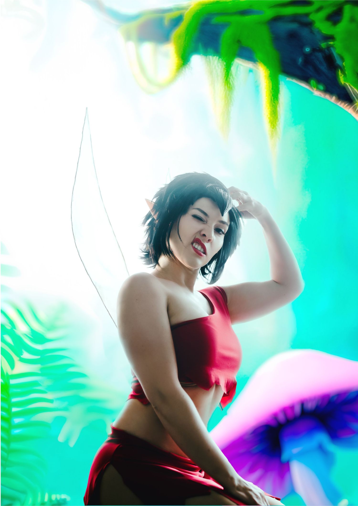 Artistic cosplay portrait with vibrant turquoise and green background effects.