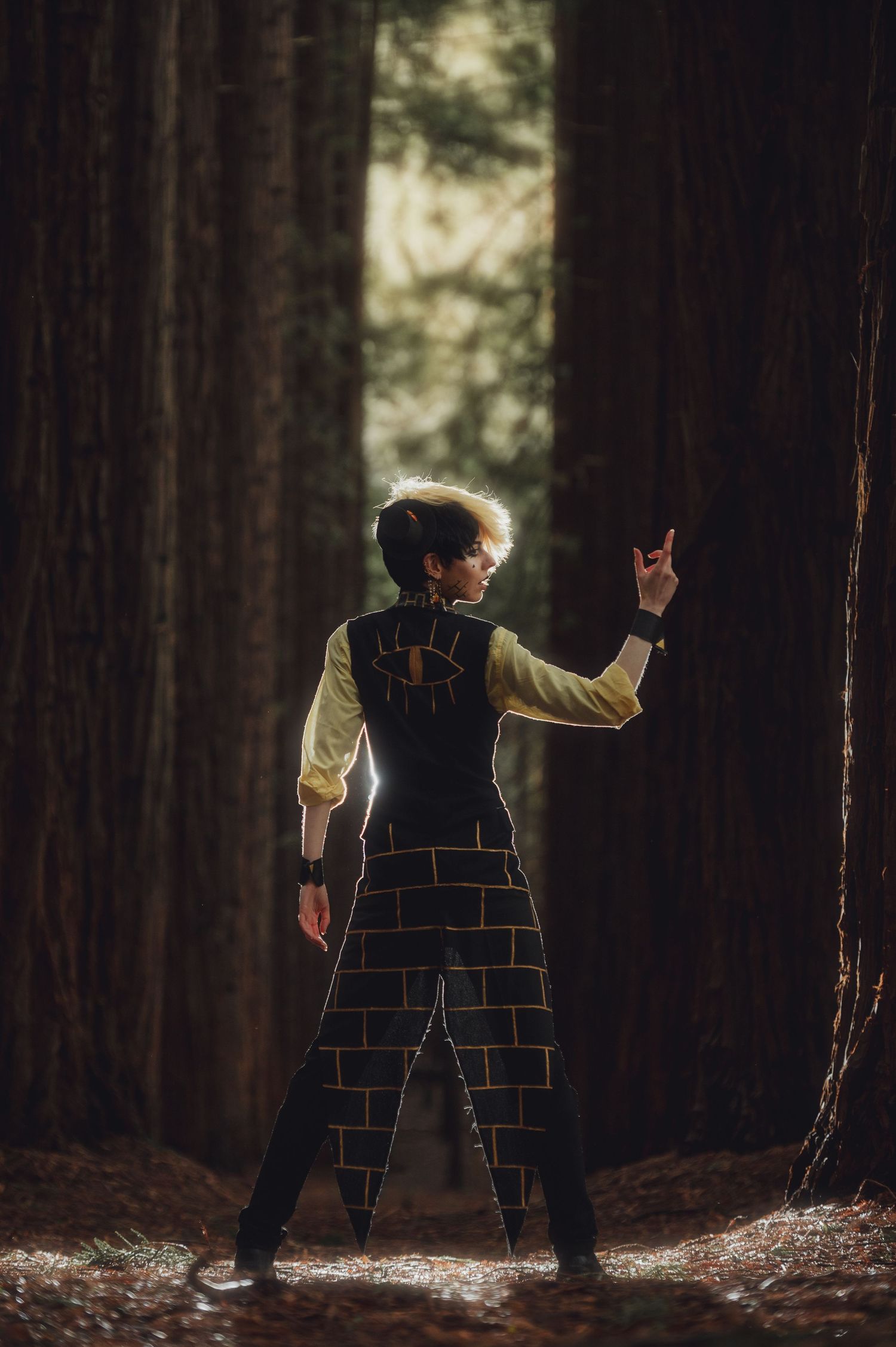 Silhouette of performers in dramatic poses against sunlit forest backdrop.