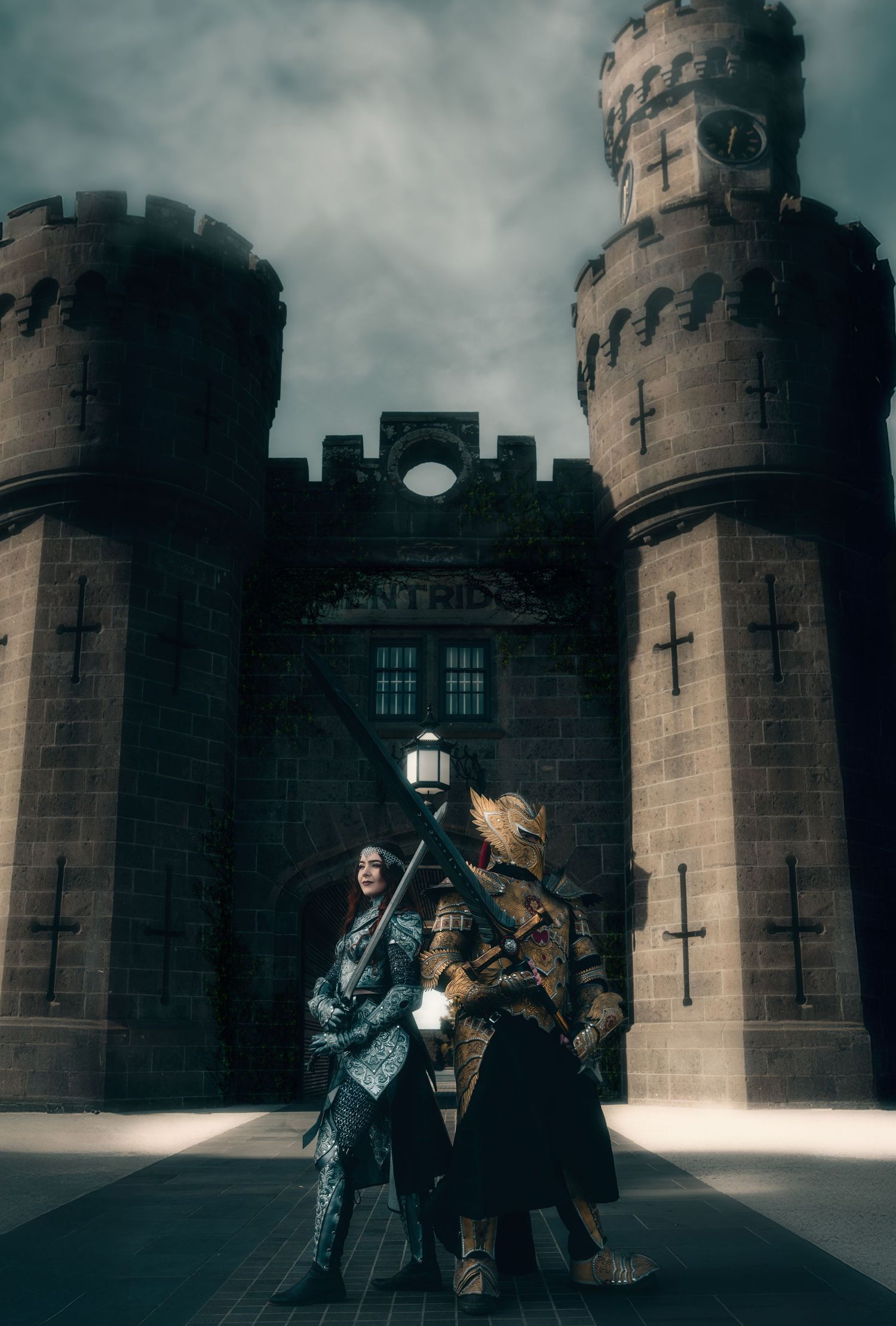 Medieval castle scene with figures in period costume near stone towers.