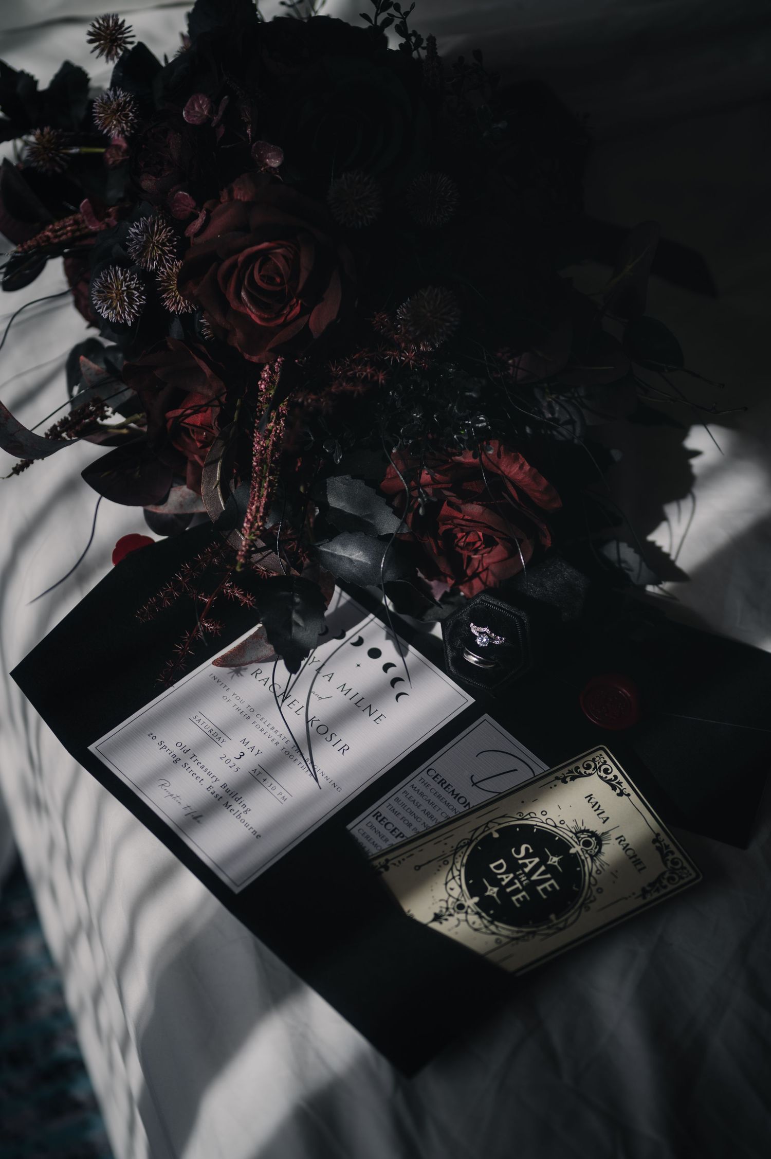 Artistic dark photography of flowers and papers with dramatic shadows.