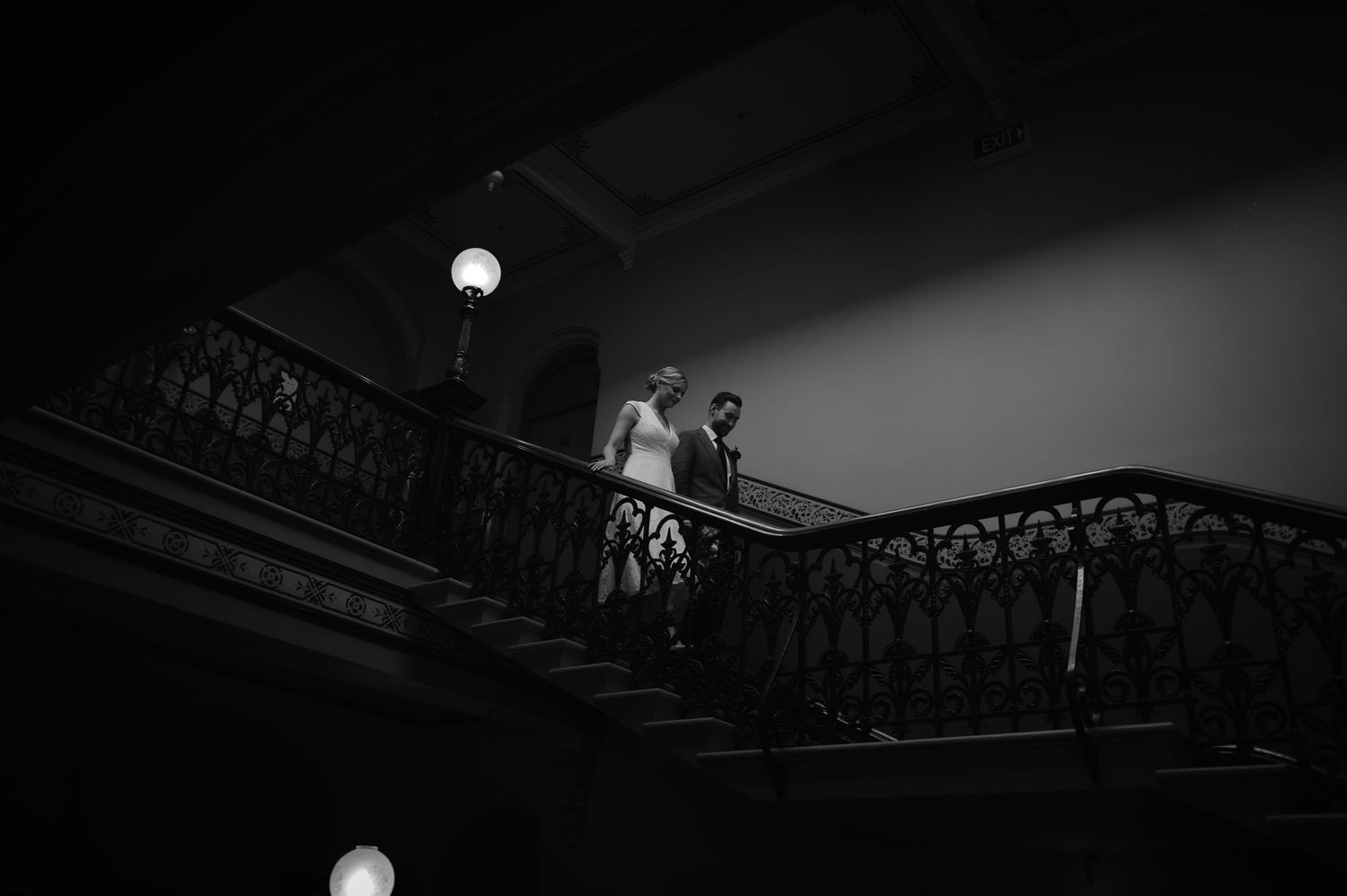 Artistic black and white shot of people on a grand staircase with dramatic lighting.