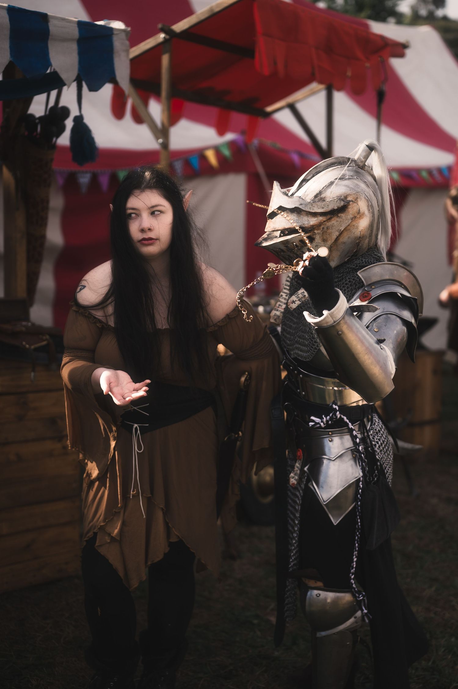Medieval fantasy fair scene with decorative hobby horses and period costumes.