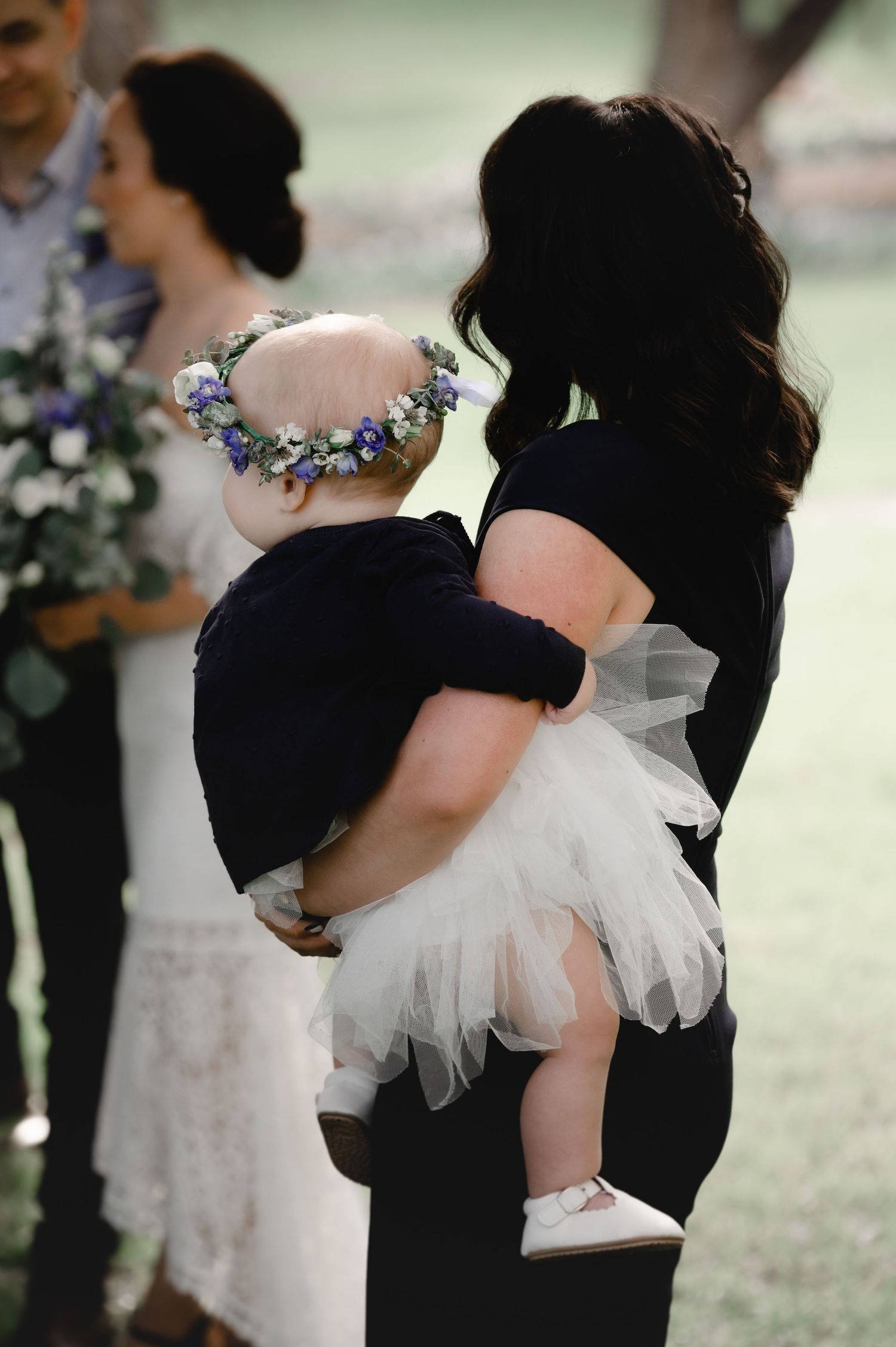 Wedding party members in black and white attire with floral accessories.