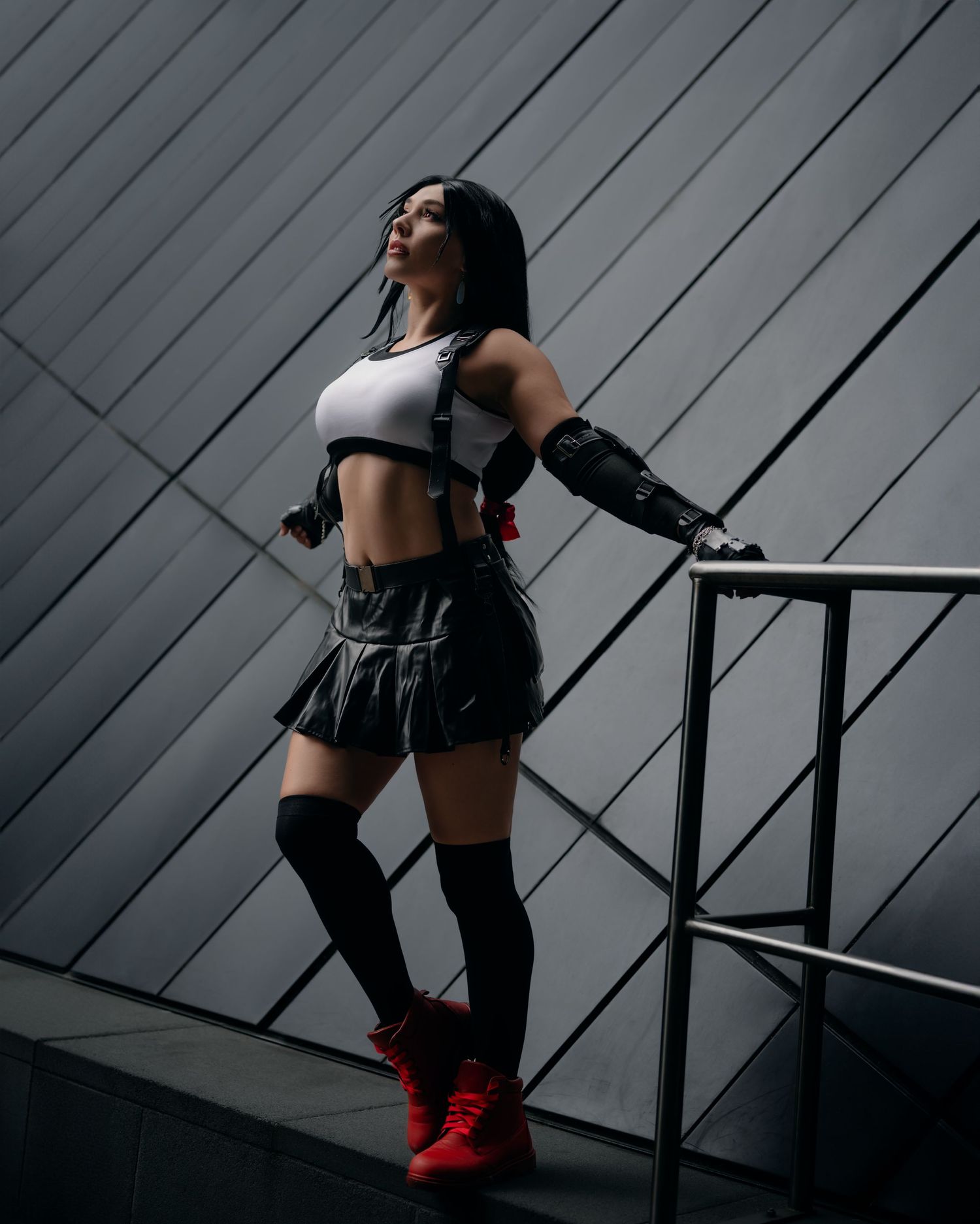 Athletic cosplay featuring sporty outfit with red boots against modern architecture.