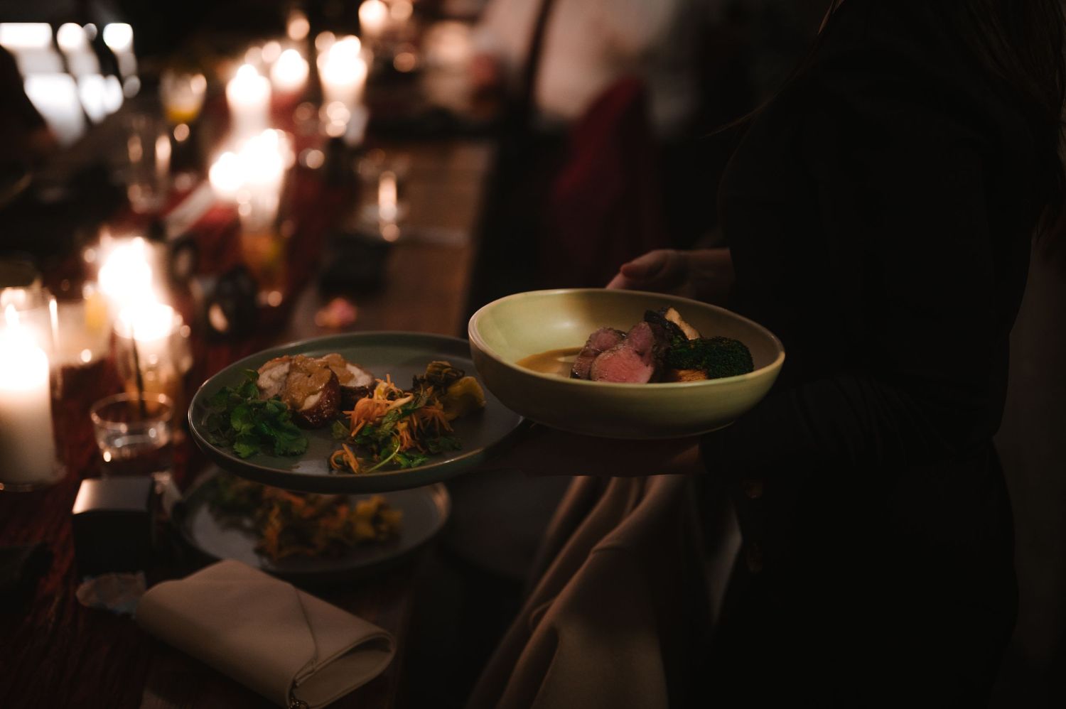 Elegant table setting with glowing candles and ambient lighting creating a romantic atmosphere.