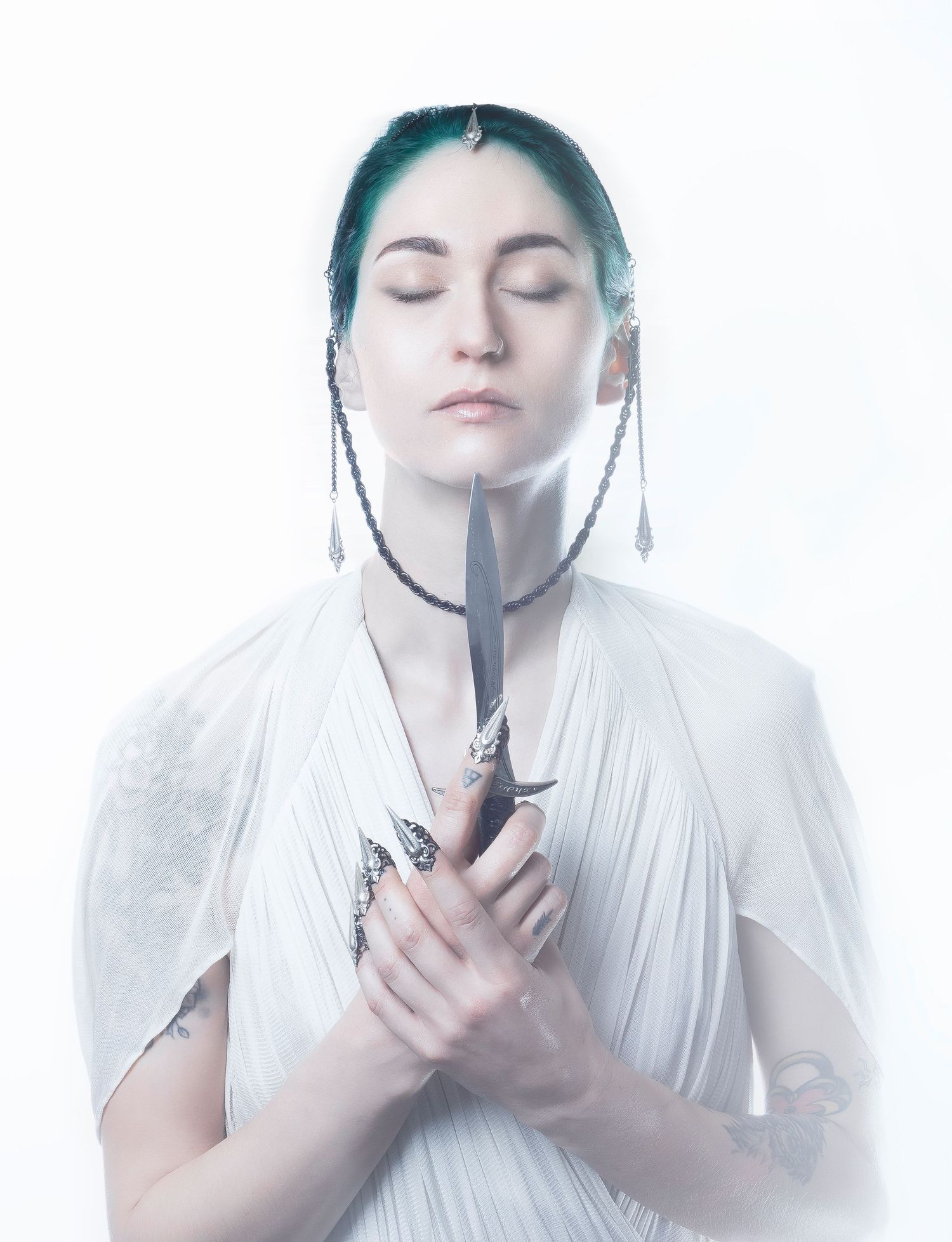 Artistic photo series showing a person in white clothing holding and examining a dark object.