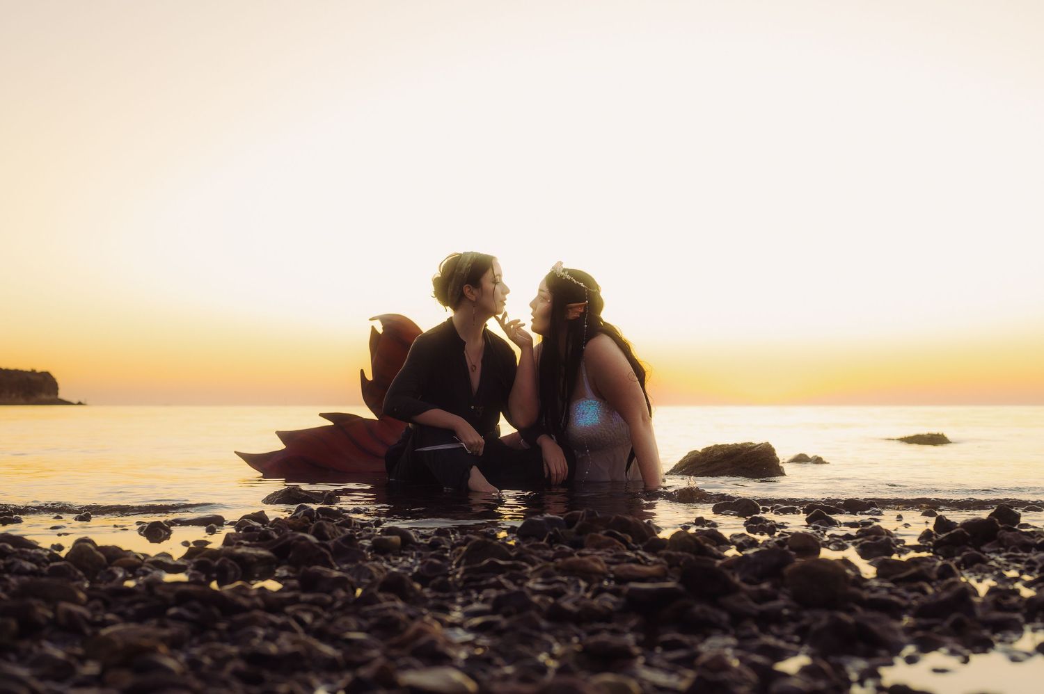 Silhouettes against sunset sky during beach photoshoot.