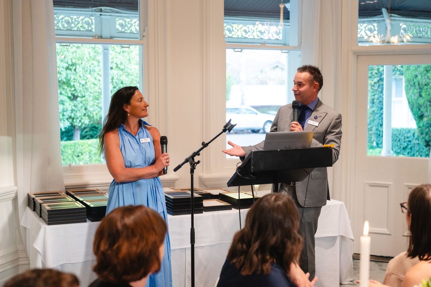 Musicians perform at an intimate indoor venue with large windows and natural lighting during a daytime concert.