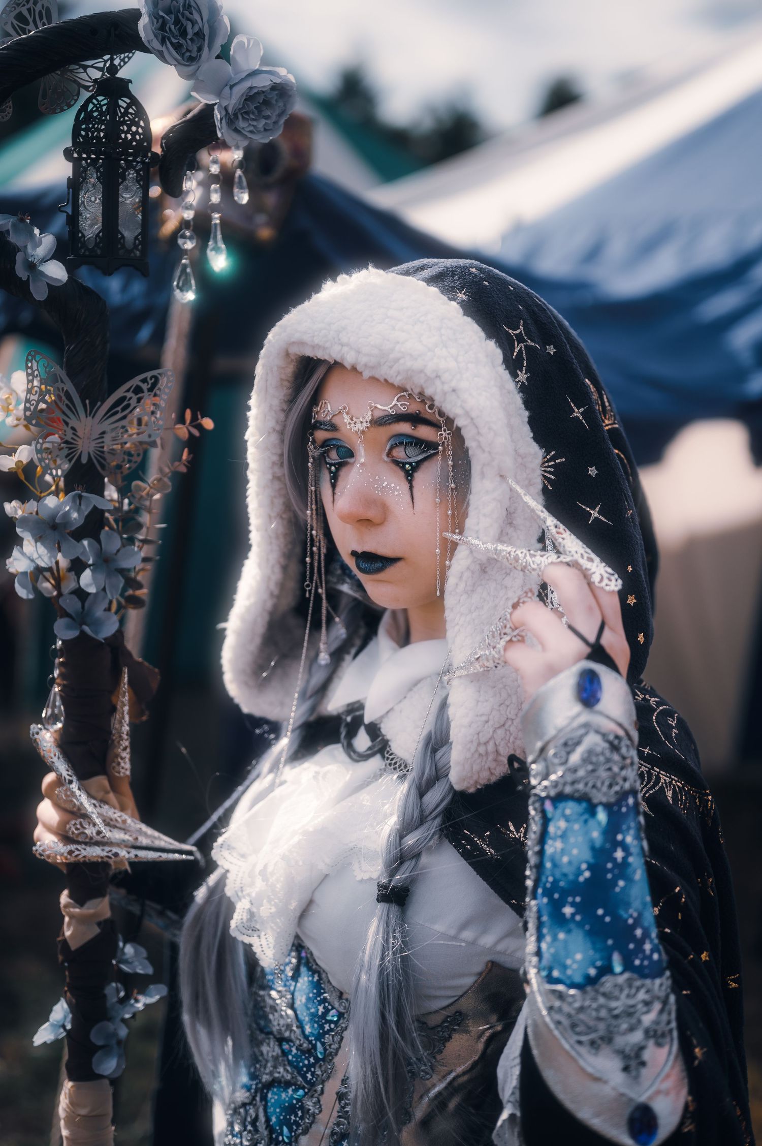 Fantasy cosplay character with white hair and blue accents in winter setting.
