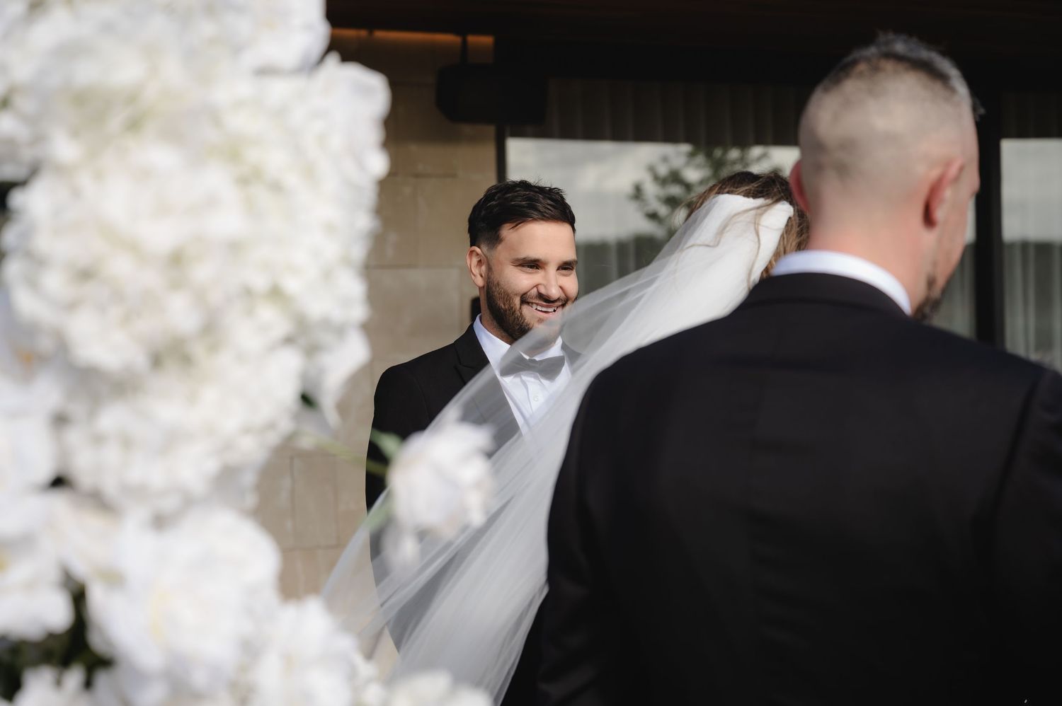 A joyful wedding moment captured through white floral decorations.