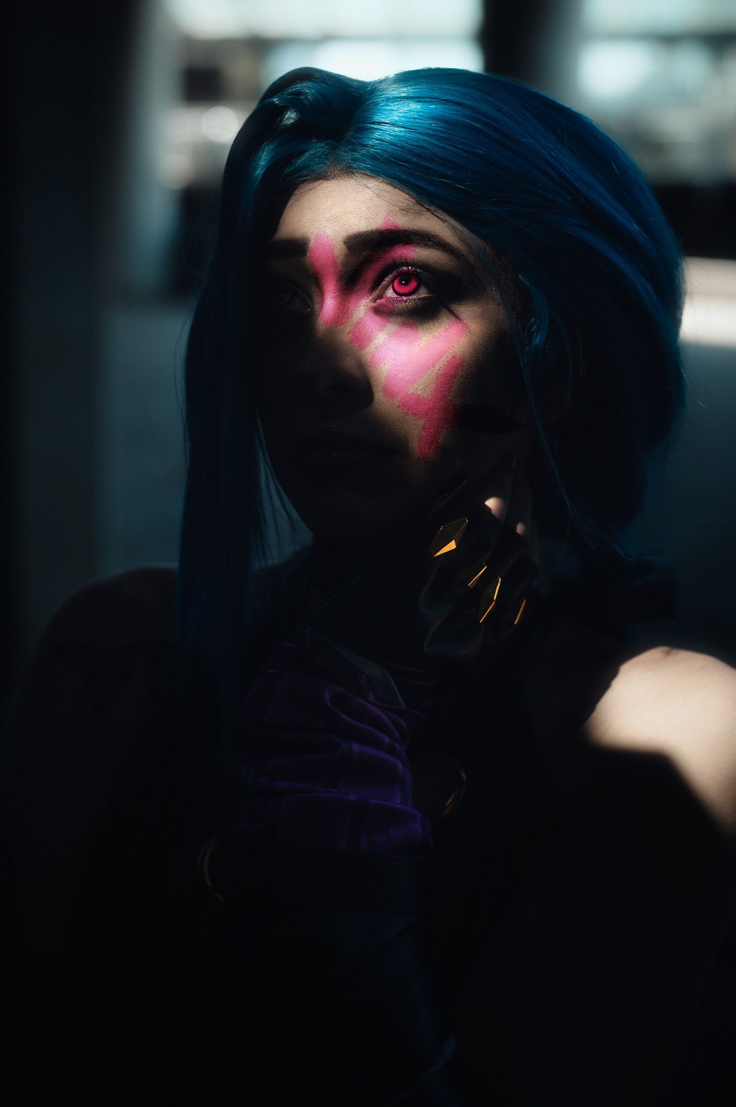 Artistic portrait with blue hair and dramatic lighting showing cyberpunk style makeup.