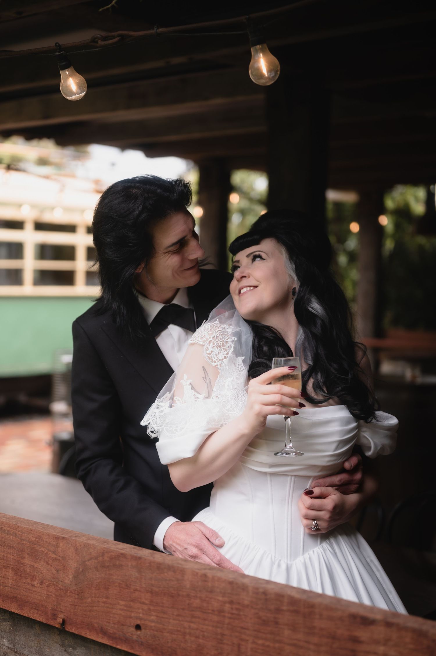 Romantic moment captured between newlyweds in vintage-inspired wedding attire.