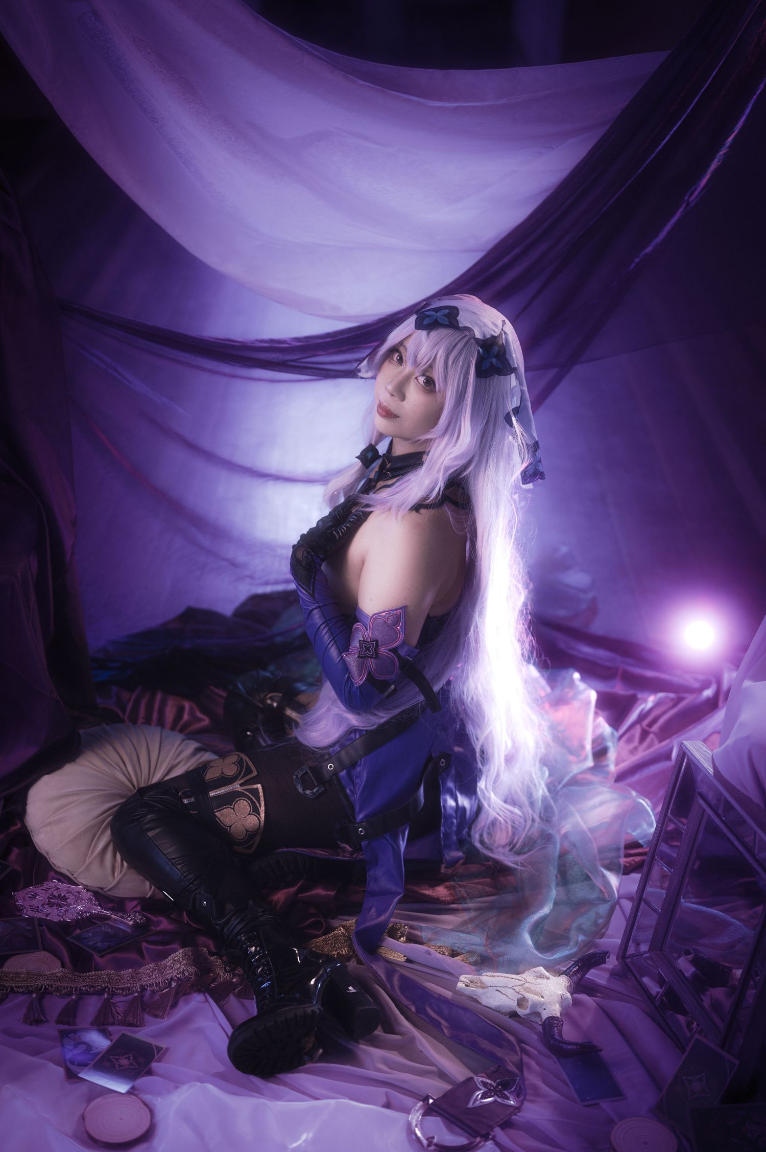 Fantasy cosplay photoshoot with purple lighting and dramatic fabric backdrop.