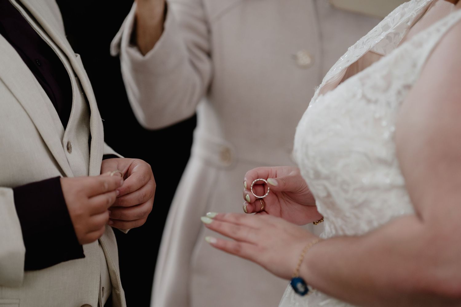 Close-up of wedding ceremony details with white attire and delicate moments.
