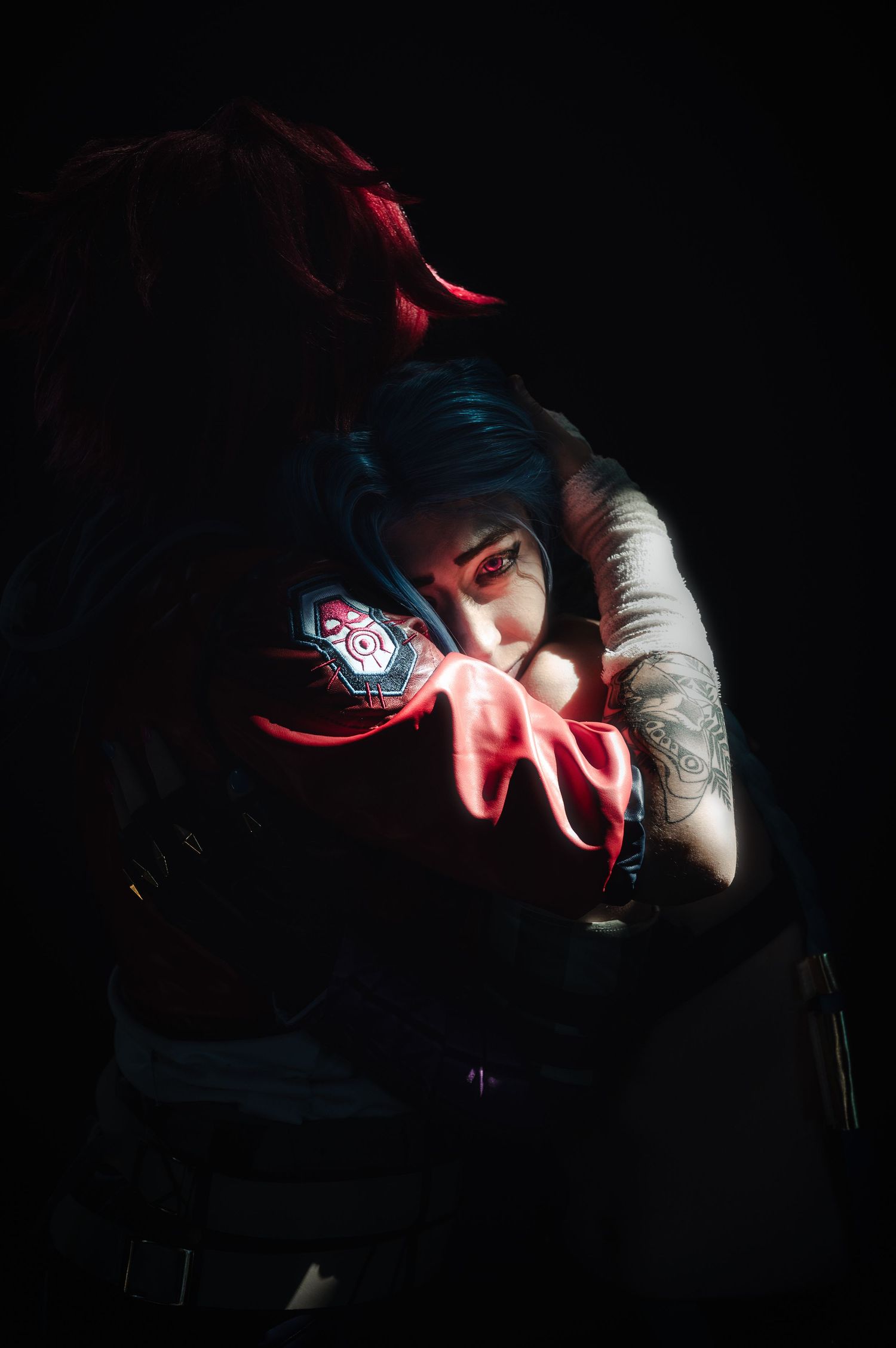 Low-key portrait with red accent lighting in dark environment.