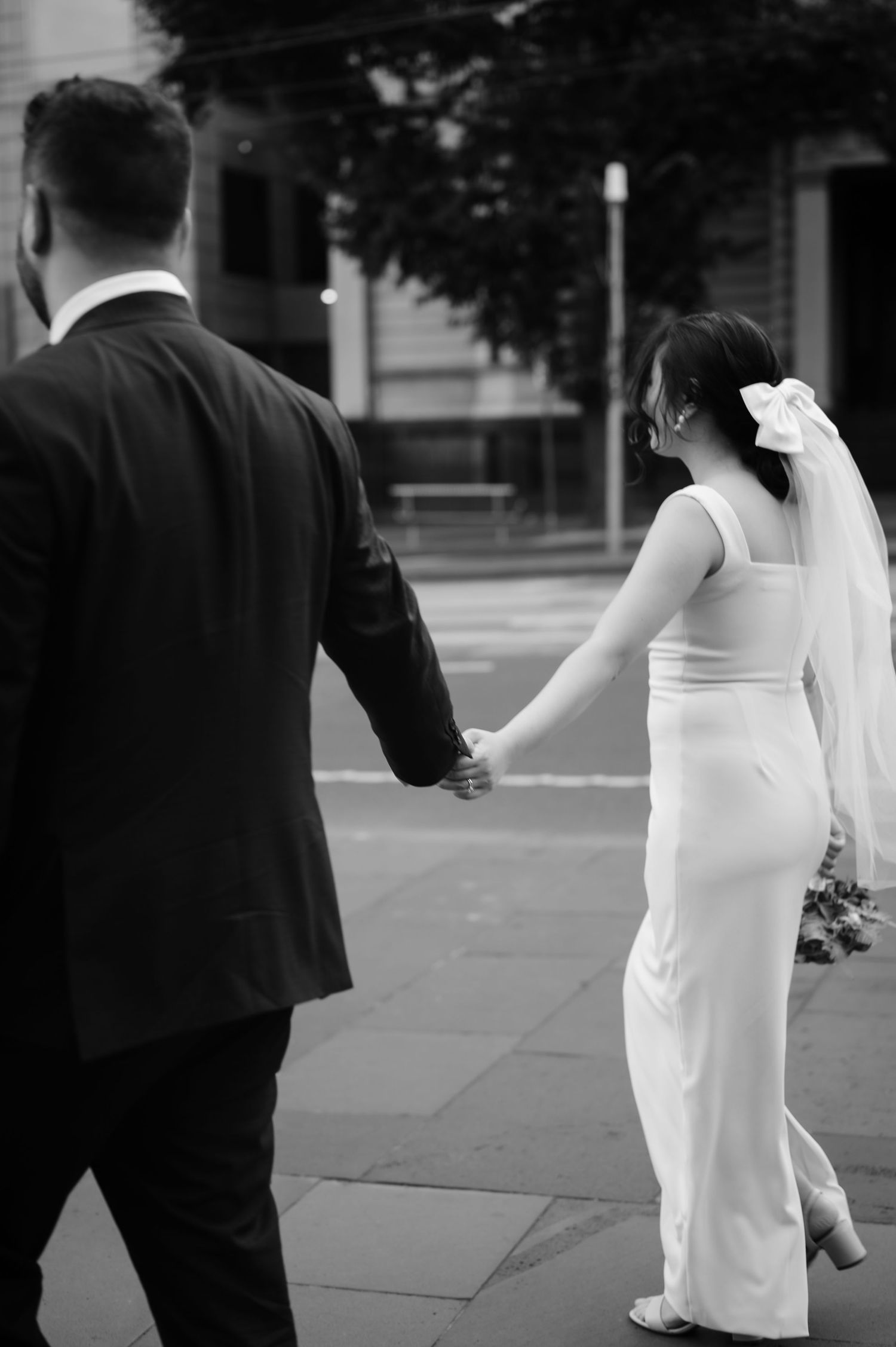 Black and white wedding portraits showing couple walking together outdoors.
