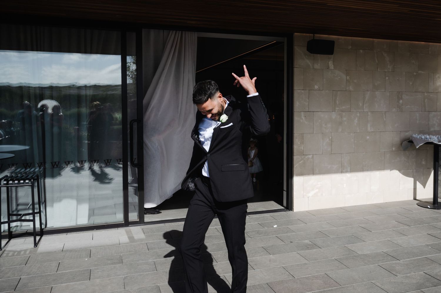 A celebratory moment captured of someone jumping with joy outside a modern building.