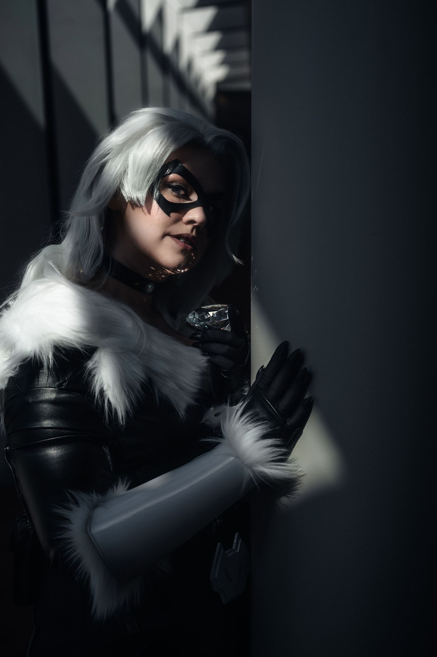 Noir-style portrait in black leather with white fur accents.