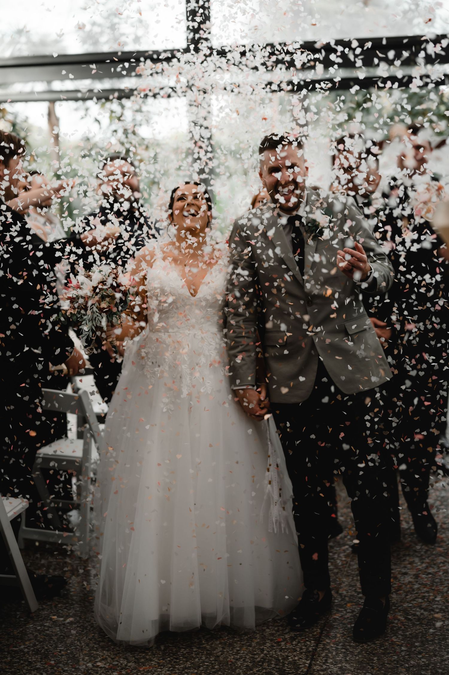 Confetti shower creates magical atmosphere during wedding celebration indoors.
